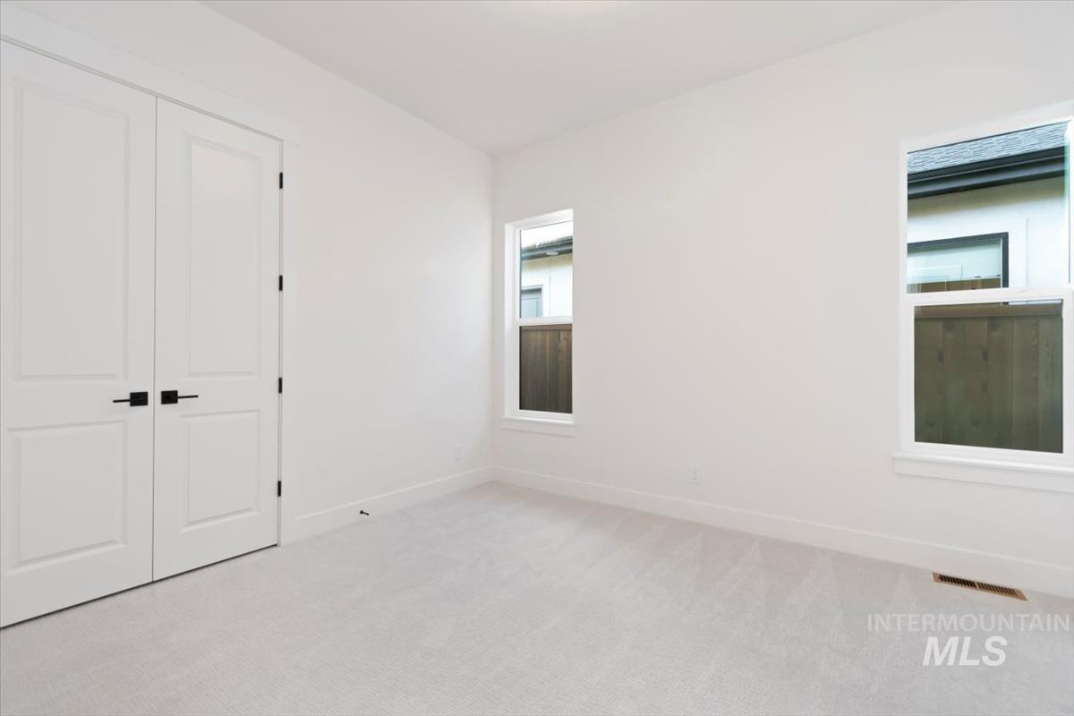Unfurnished bedroom with light carpet and a closet