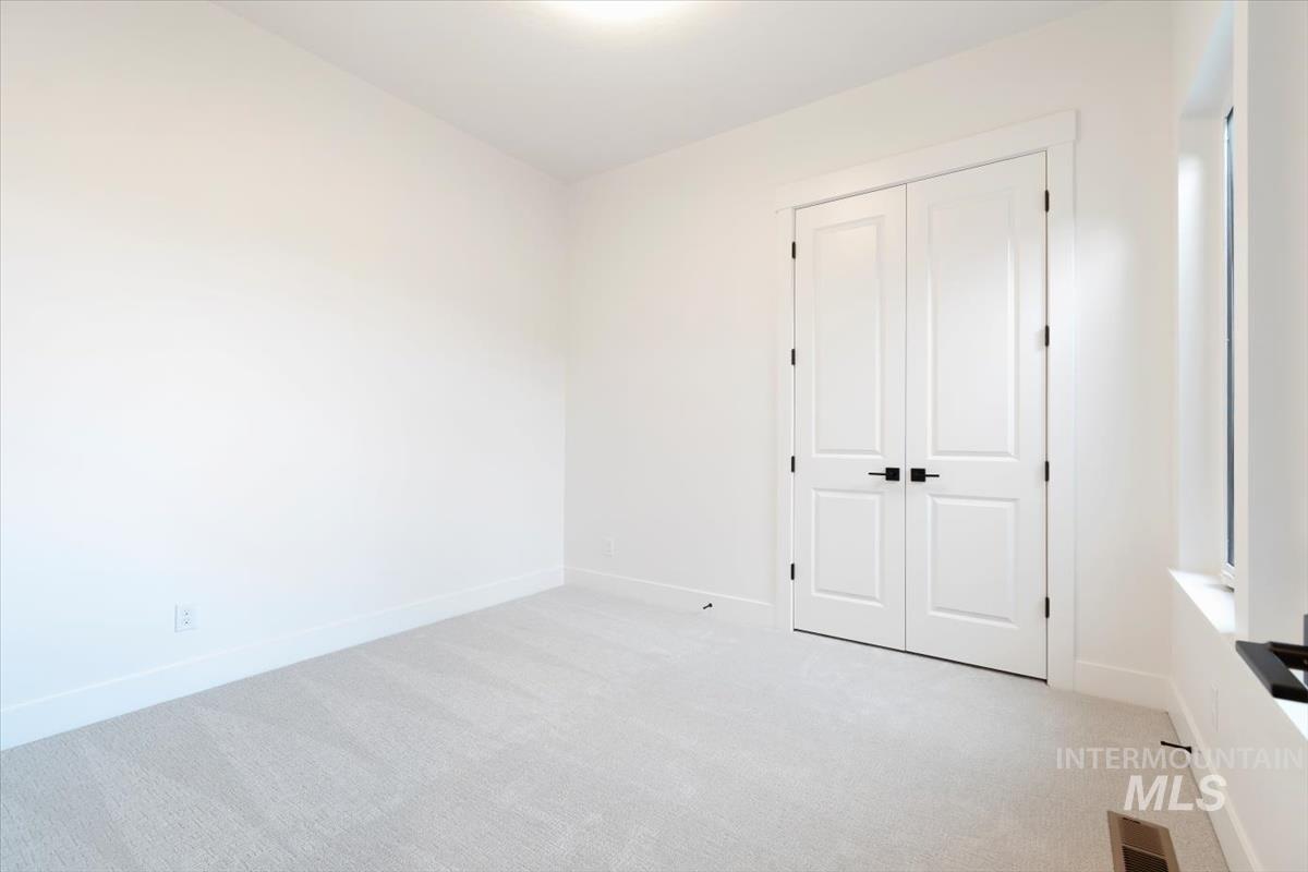 Unfurnished bedroom featuring light colored carpet and a closet