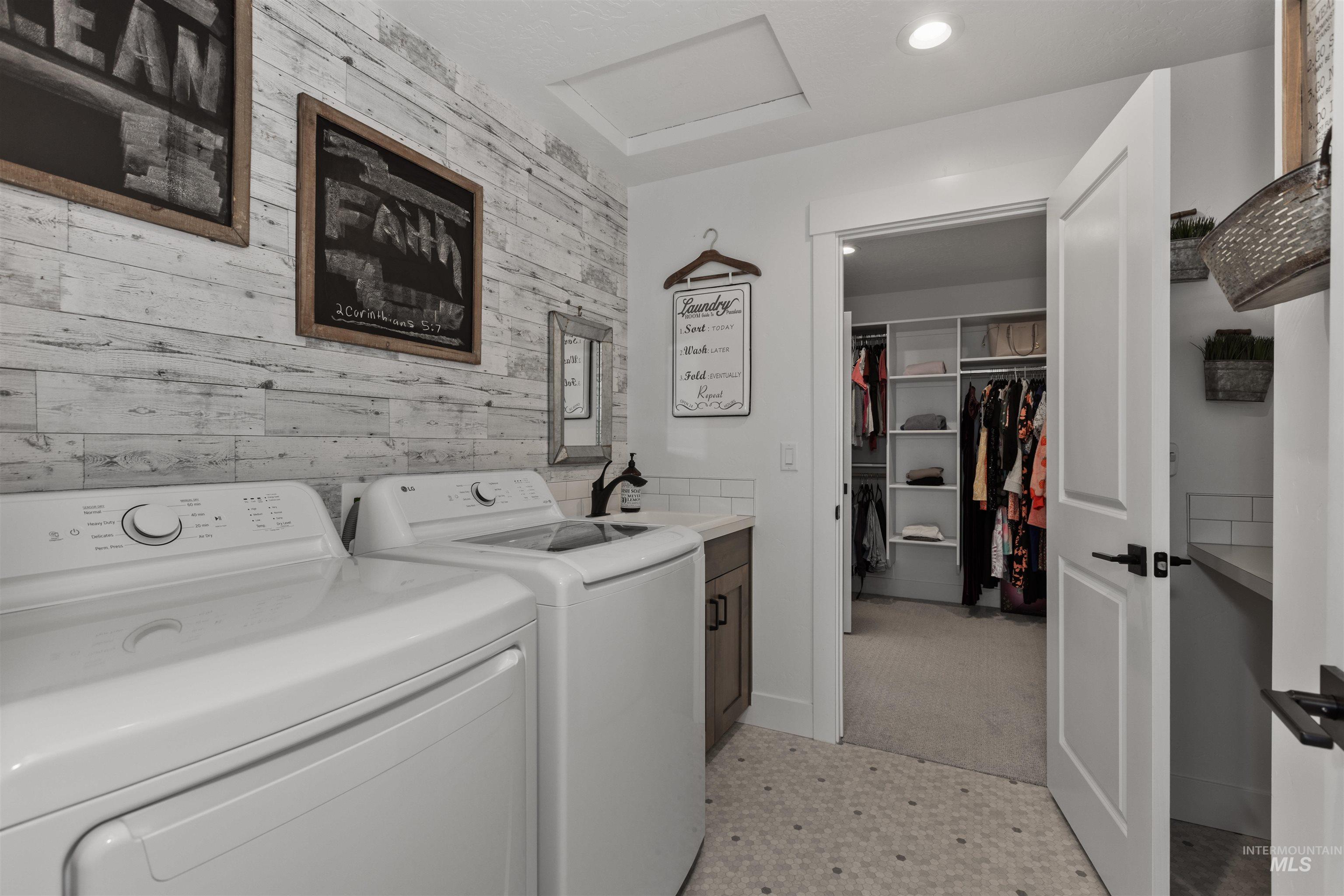 Laundry area with wooden walls, attic access, washing machine and dryer, cabinet space, and recessed lighting