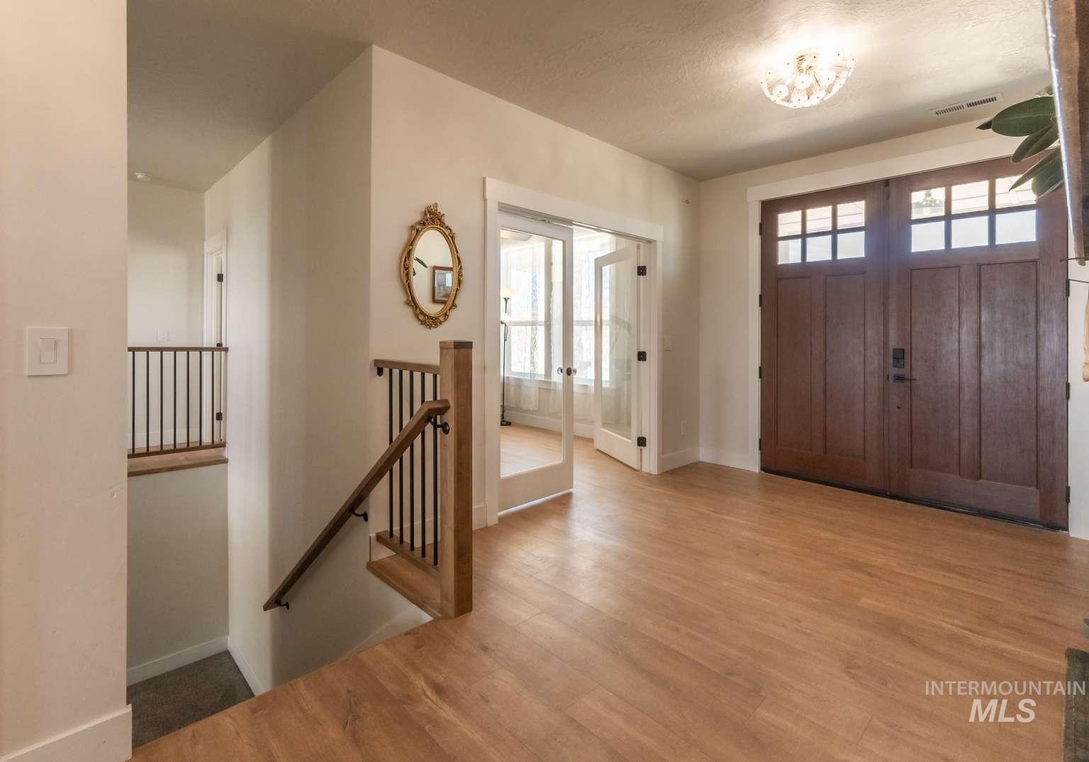 Entrance foyer featuring plenty of natural light, french doors, wood finished floors, and a textured ceiling