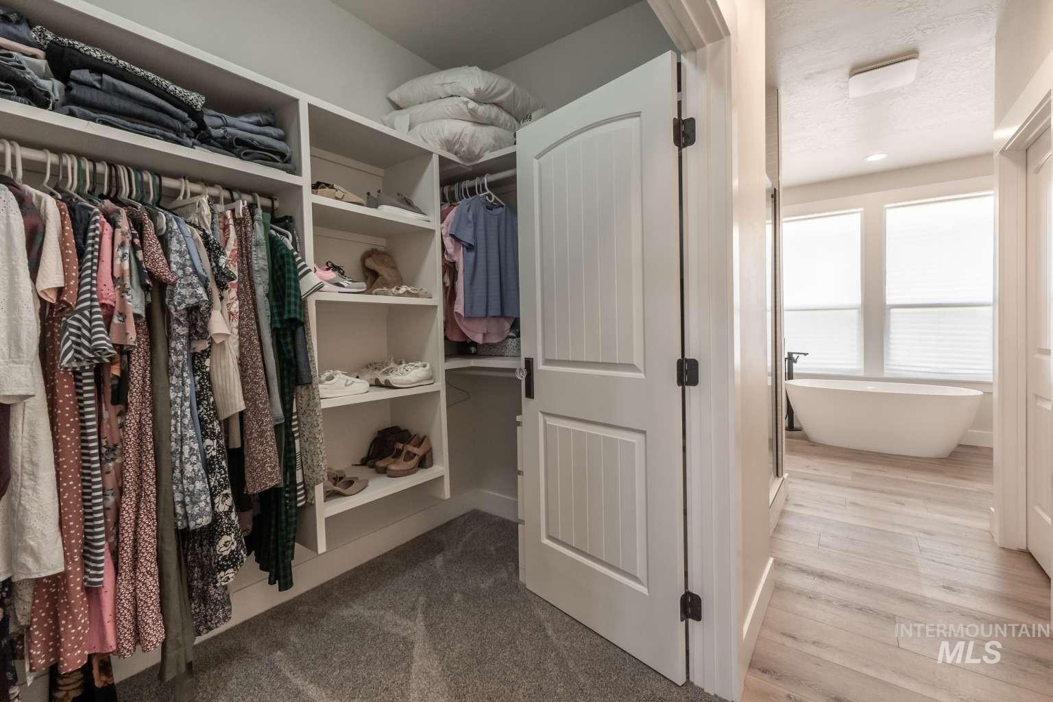 Spacious closet with dark wood-style flooring