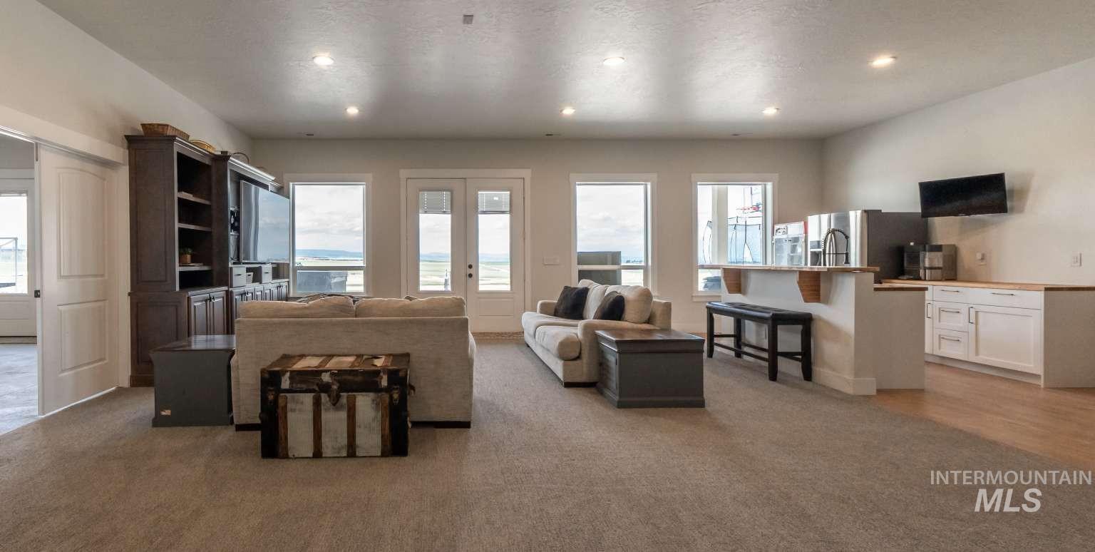 Living area featuring healthy amount of natural light, recessed lighting, a textured ceiling, and light colored carpet