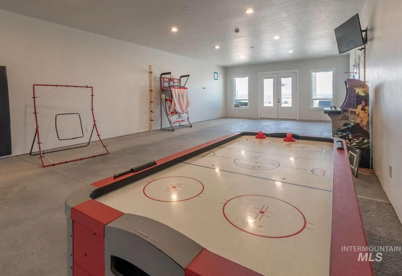 Game room featuring french doors, concrete floors, and recessed lighting