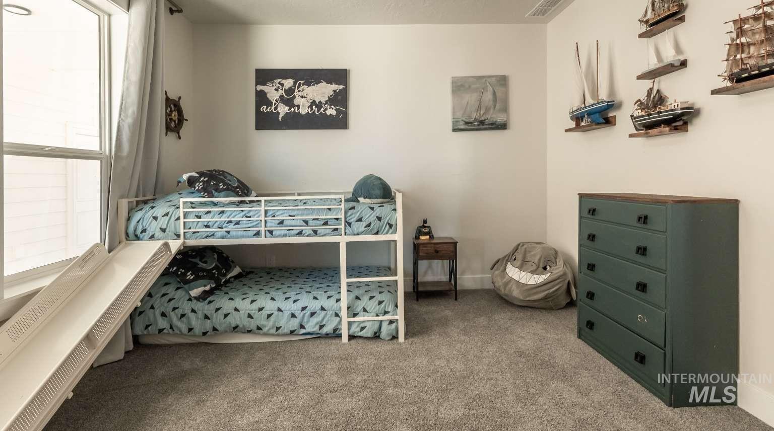 Bedroom featuring light carpet and baseboards