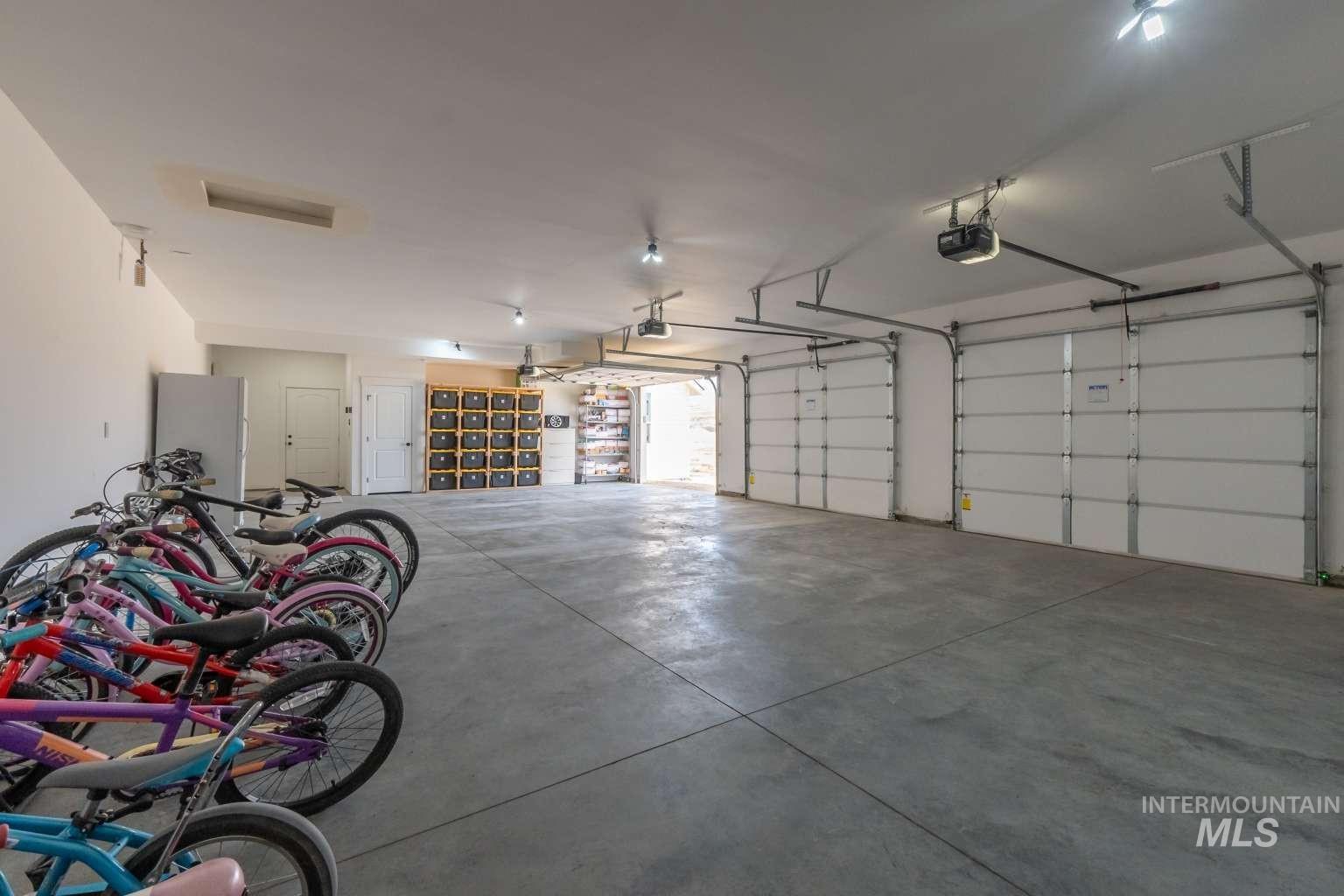 Garage with freestanding refrigerator and a garage door opener