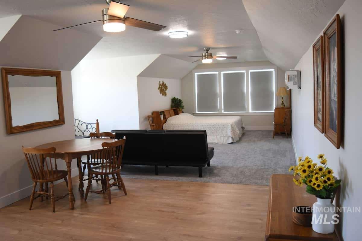 Bedroom featuring vaulted ceiling, a ceiling fan, and light wood-style flooring