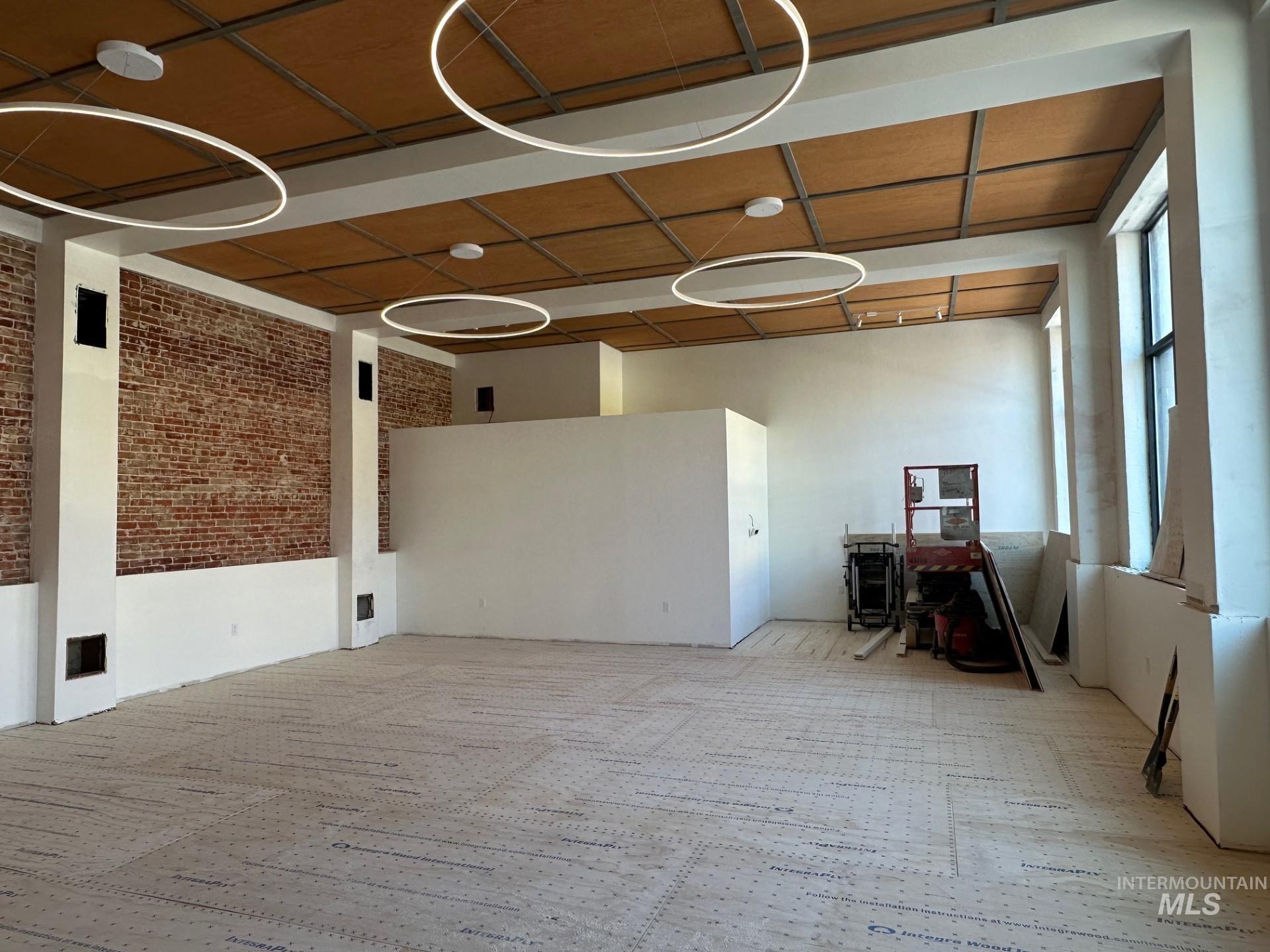 Carpeted spare room with brick wall