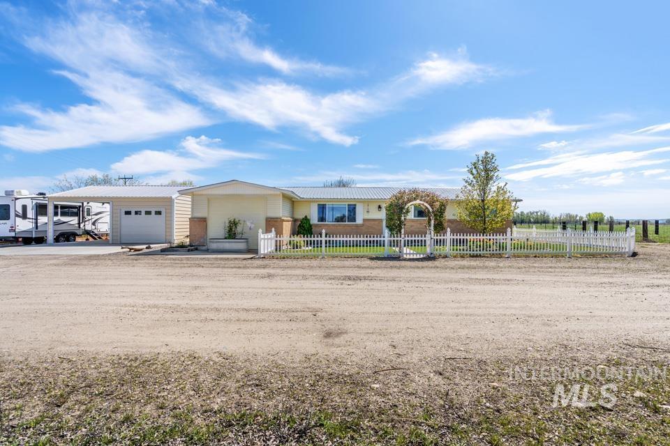 View of front facade featuring an attached garage, a fenced front yard, and concrete driveway
