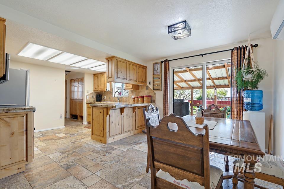 Dining space with stone tile flooring and baseboards