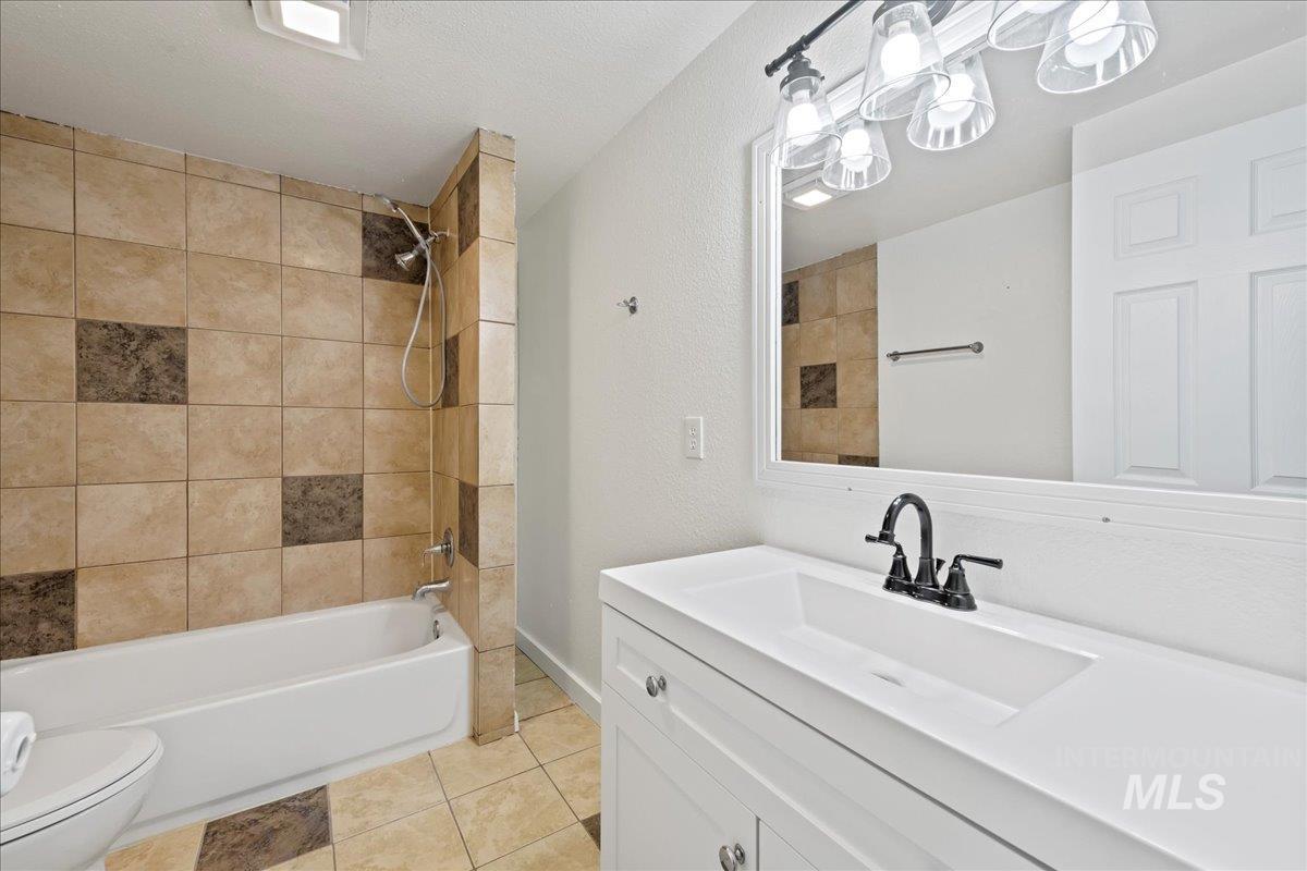 Full bathroom featuring vanity,  shower combination, and tile floors