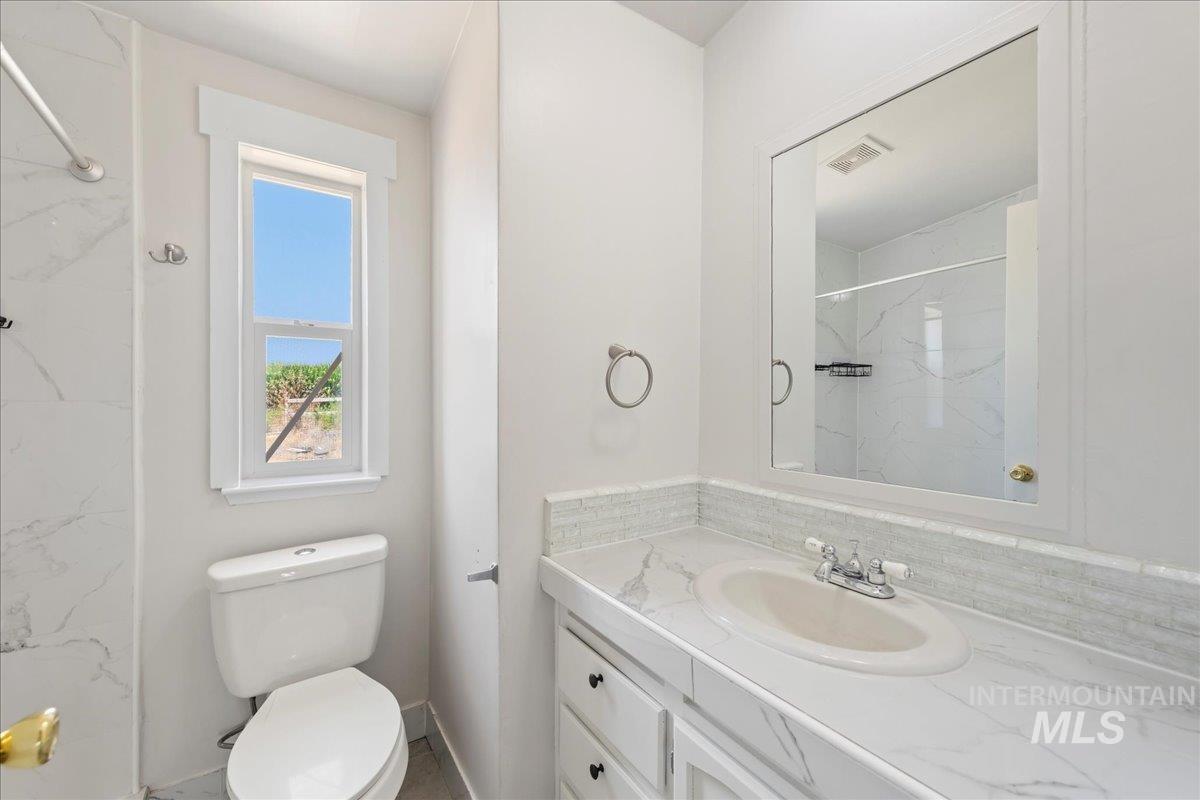 Full bathroom featuring vanity and a marble finish shower