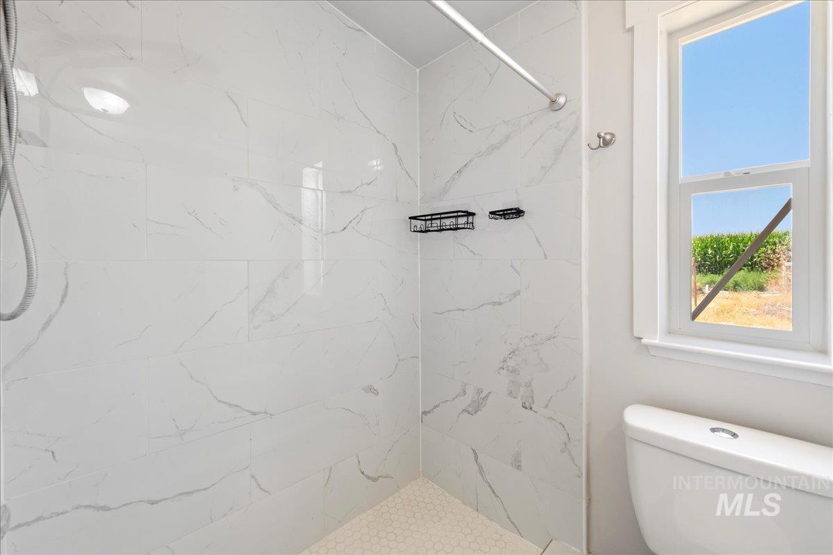 Bathroom with a marble finish shower and sink.
