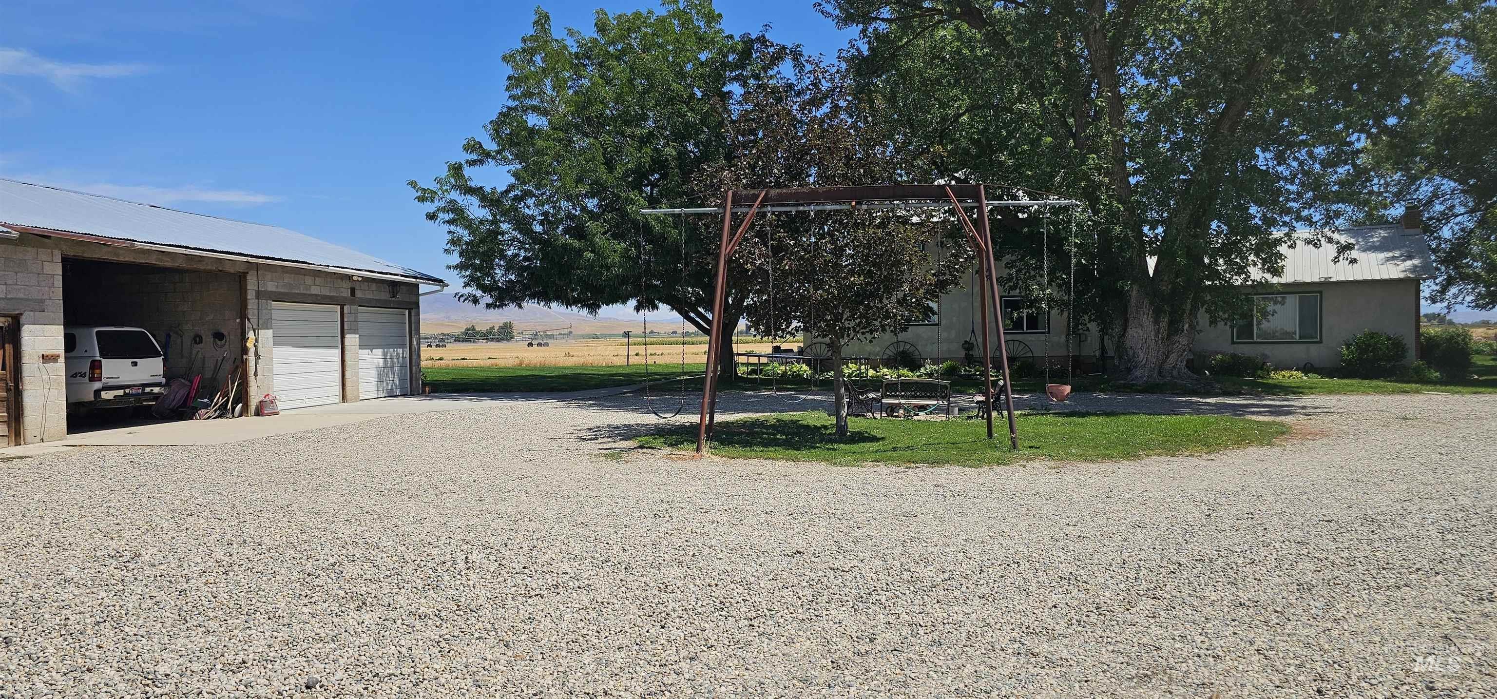 View of yard with a garage, an outbuilding, and gravel driveway