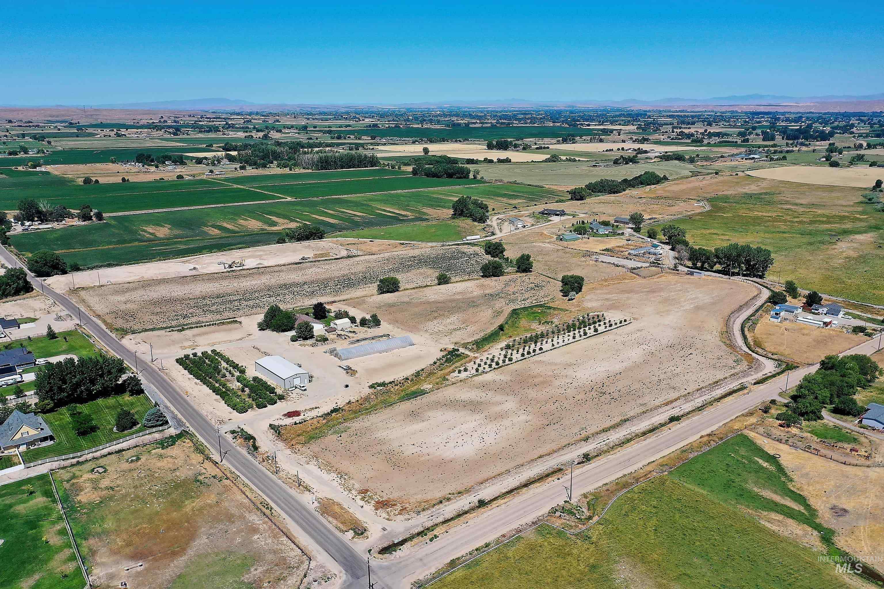 Aerial overview of property's location featuring rural landscape, mountains, and rows of crops