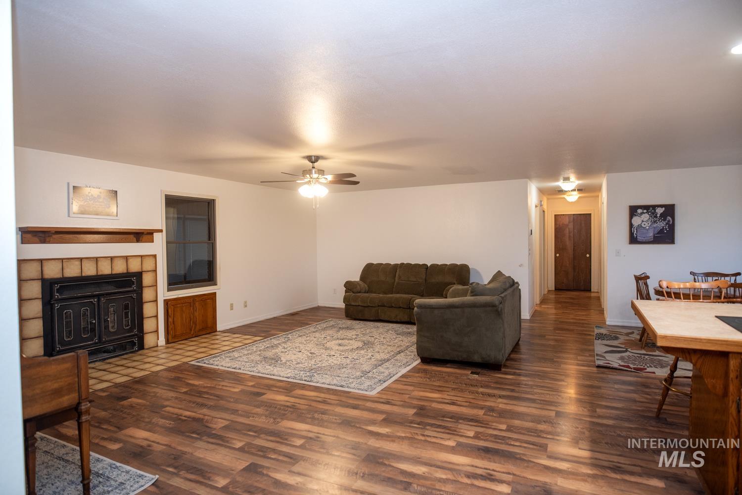 Living room with dark wood-type flooring and ceiling fan