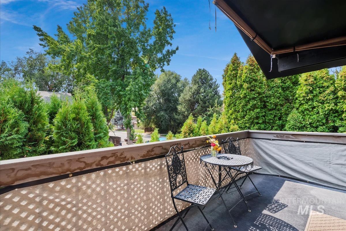 Balcony featuring view of wooded area