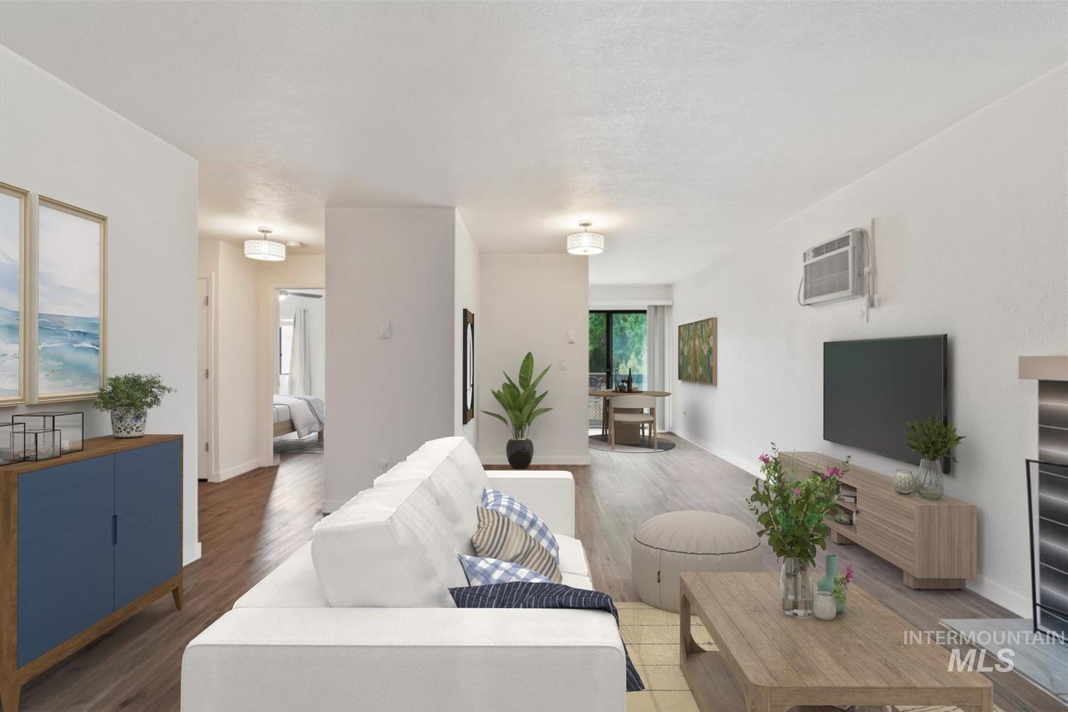 Living area featuring wood finished floors and a wall mounted air conditioner