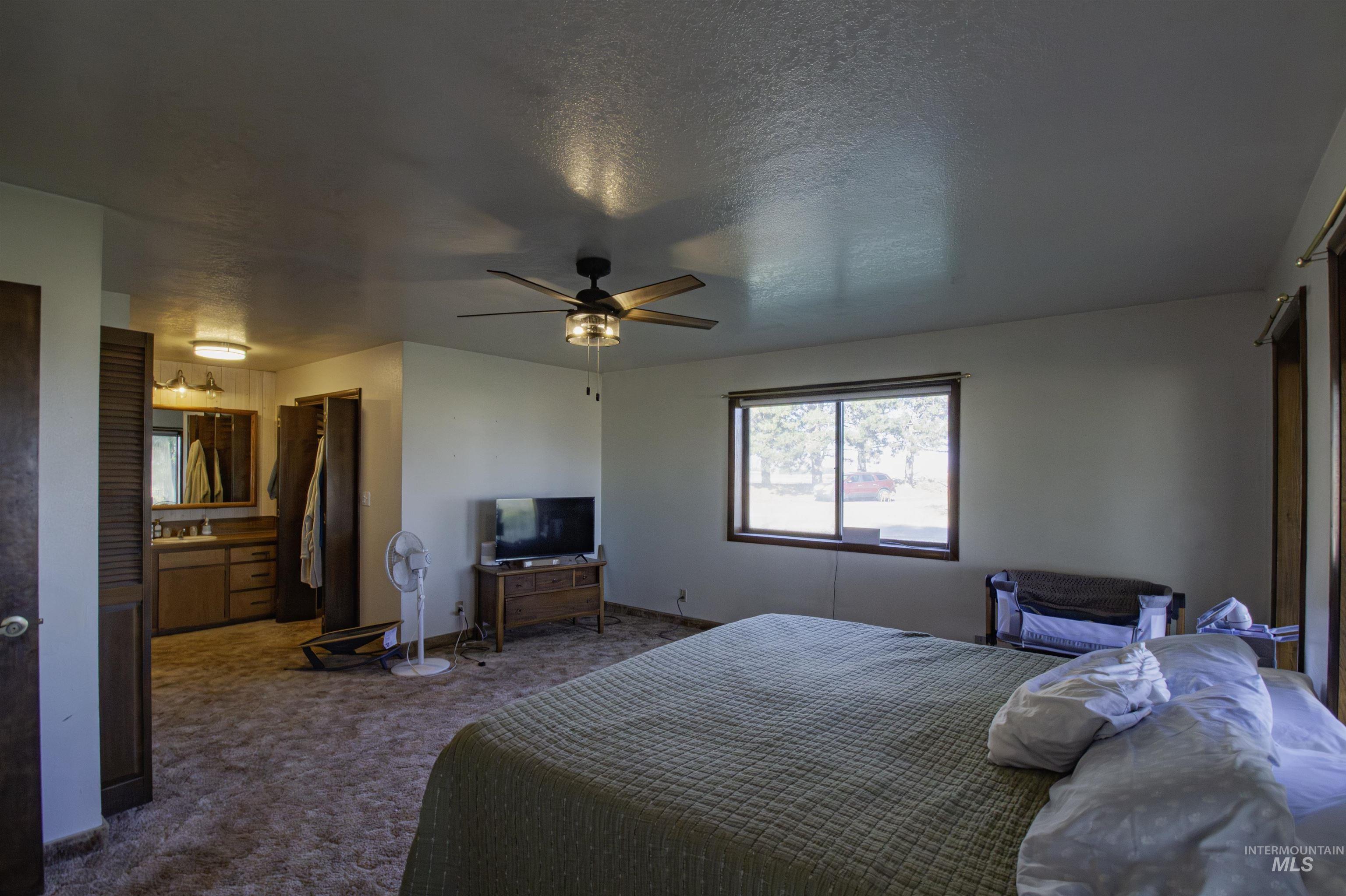 Carpeted bedroom featuring a textured ceiling, a closet, and ceiling fan