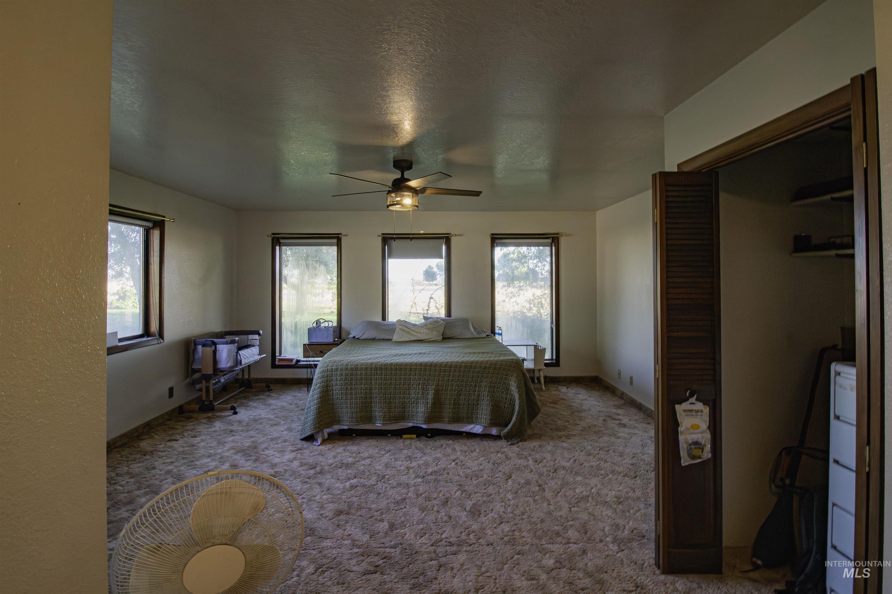 Bedroom featuring carpet floors, a textured ceiling, and a ceiling fan