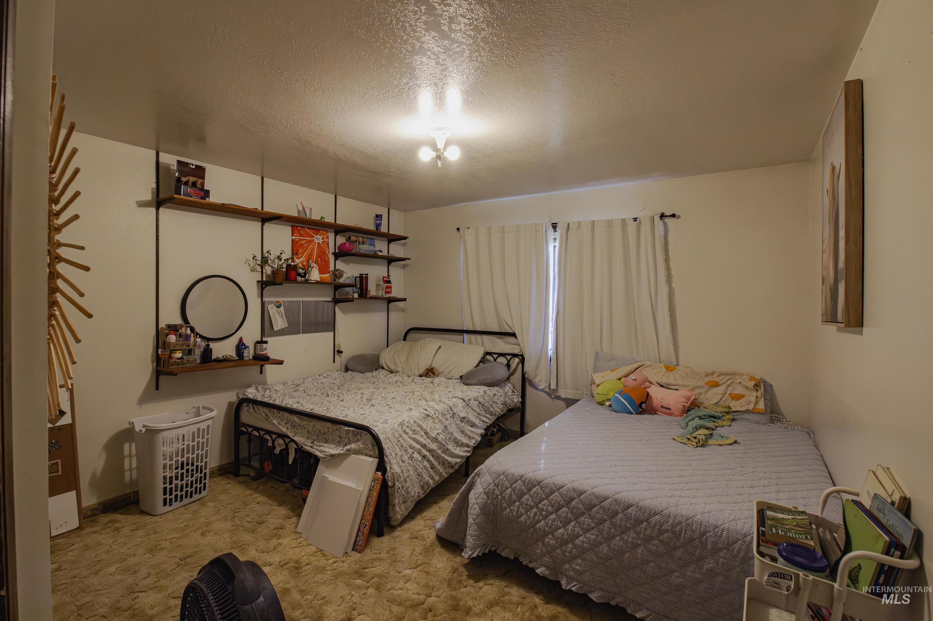 Bedroom featuring a textured ceiling and light carpet