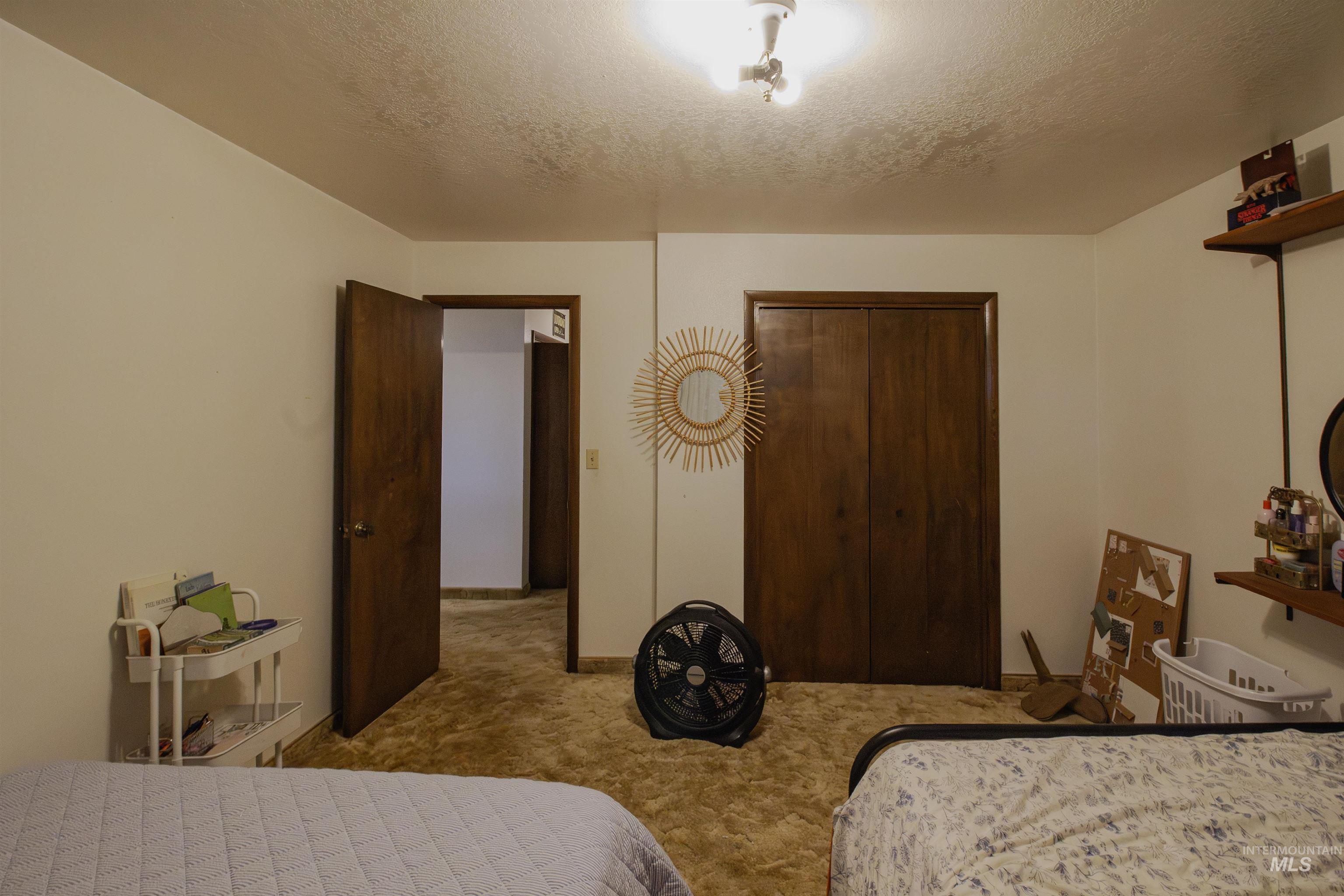 Bedroom featuring a textured ceiling, carpet floors, and a closet