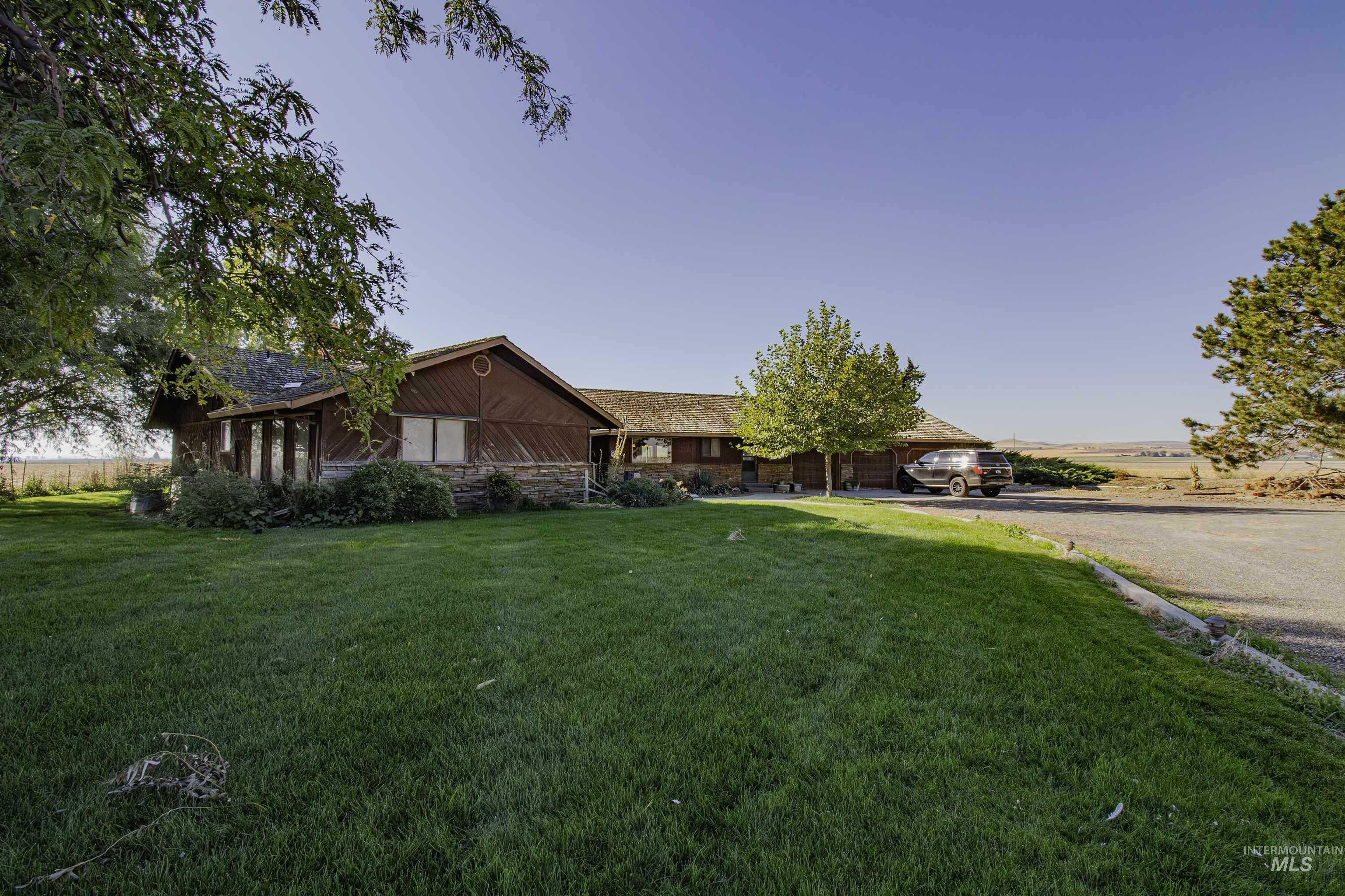 Single story home featuring a front yard and stone siding