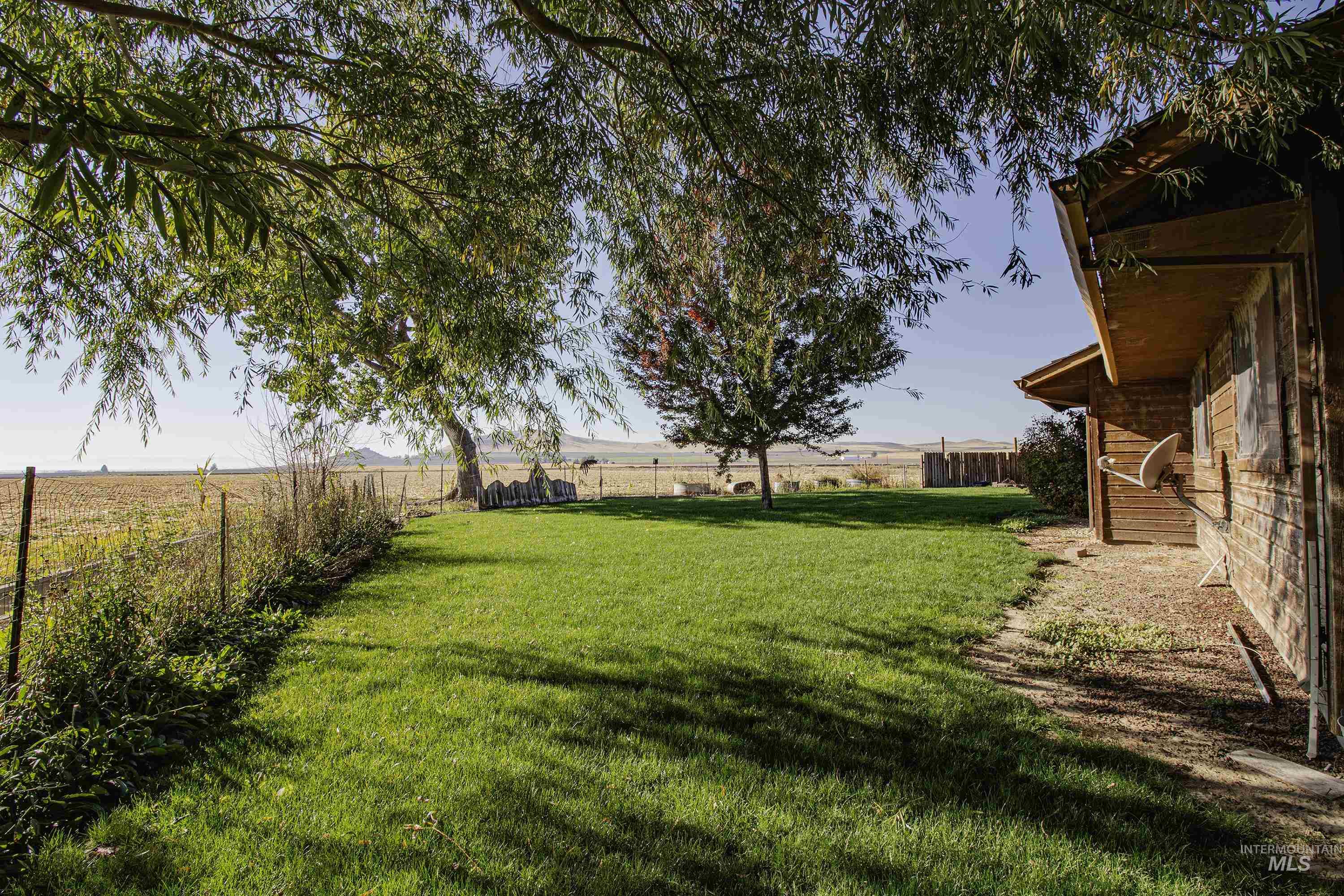 Fenced backyard featuring a view of rural / pastoral area
