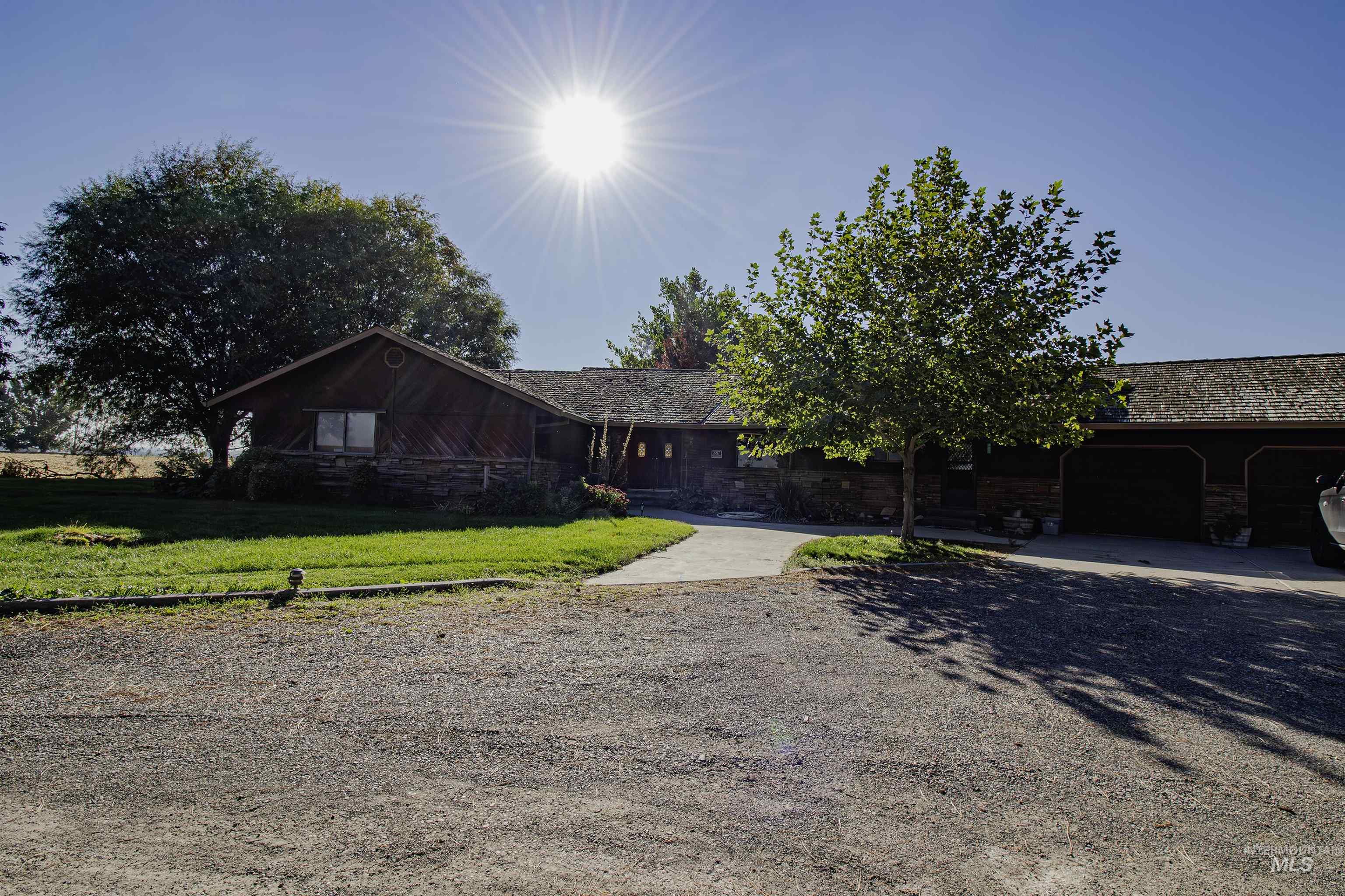 View of front of property featuring a front lawn, a garage, and driveway