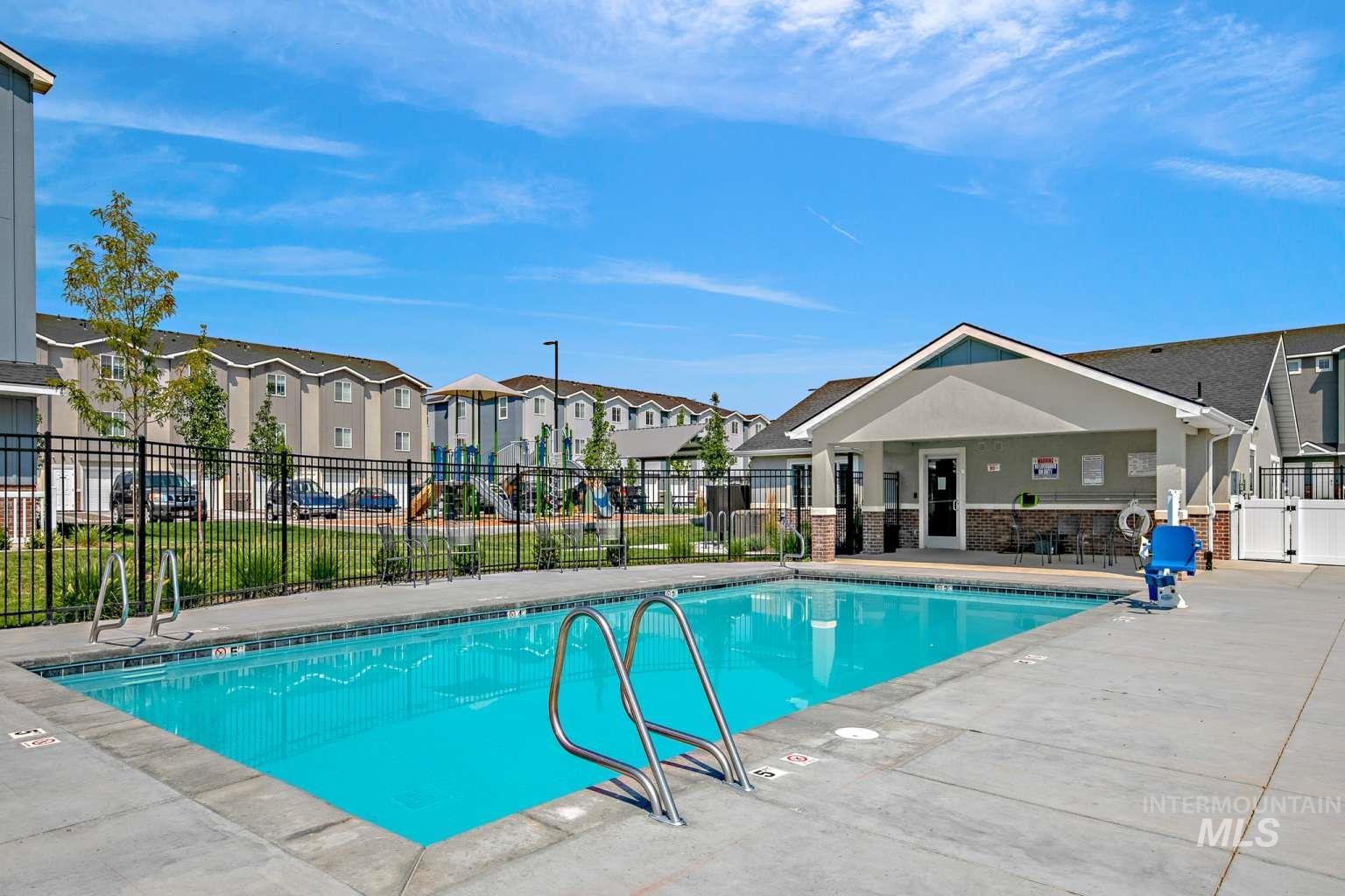 Community pool with a patio area and a residential view