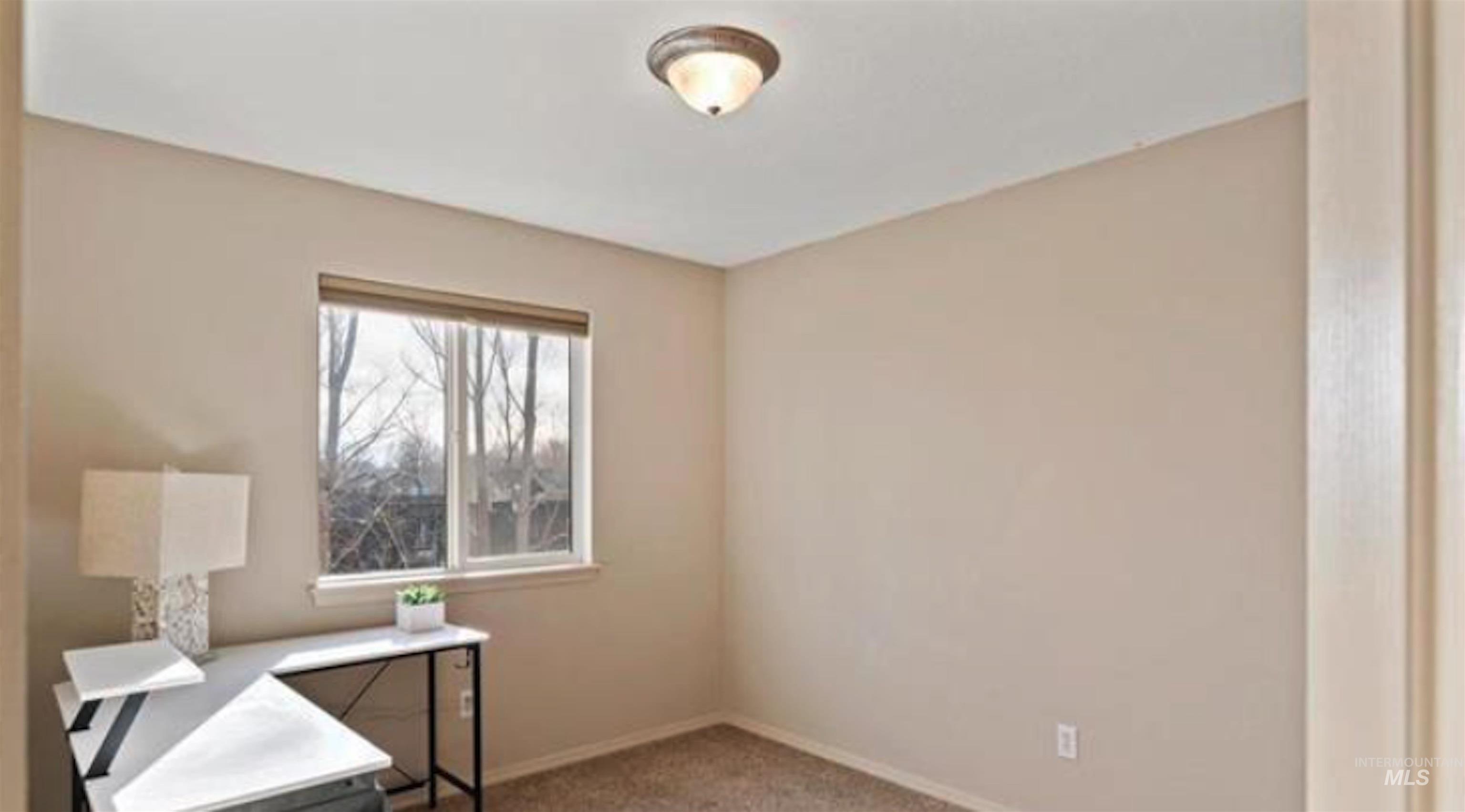 Unfurnished office featuring light colored carpet and baseboards