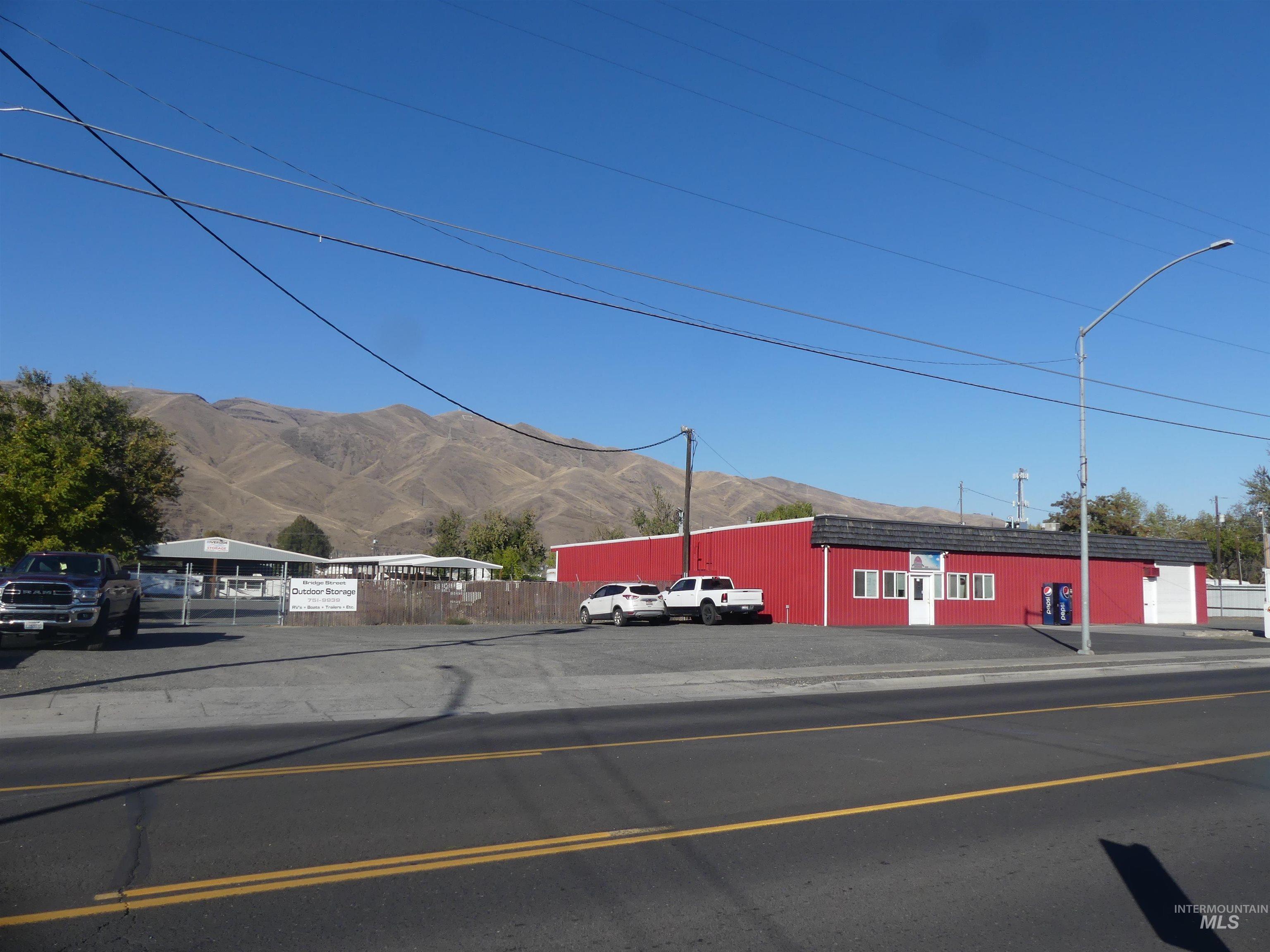 View of asphalt street with a mountain view, street lights, sidewalks, and curbs