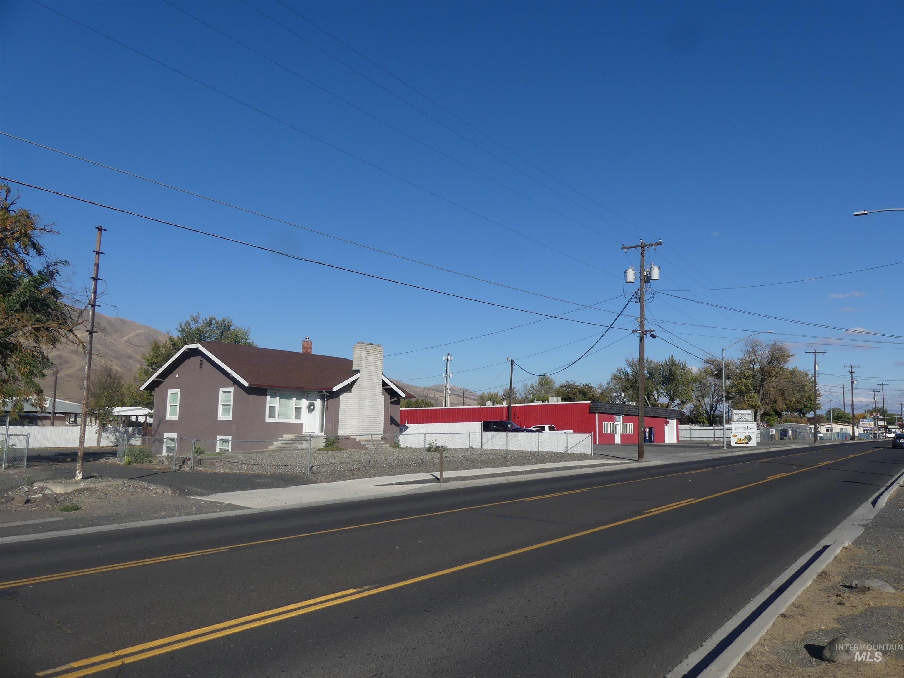 View of asphalt road featuring street lights and sidewalks