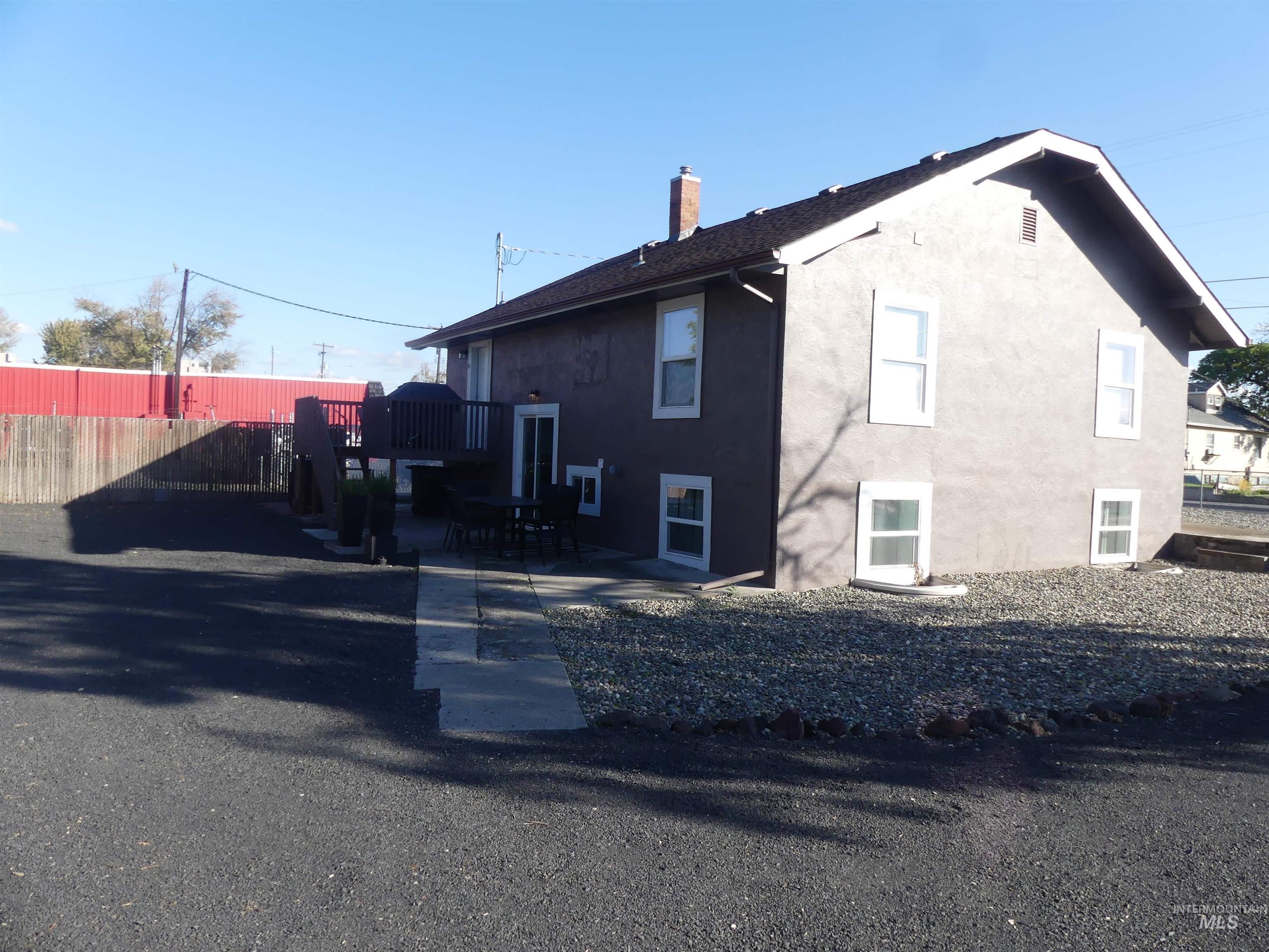 View of side of property featuring stucco siding, a patio, and a chimney