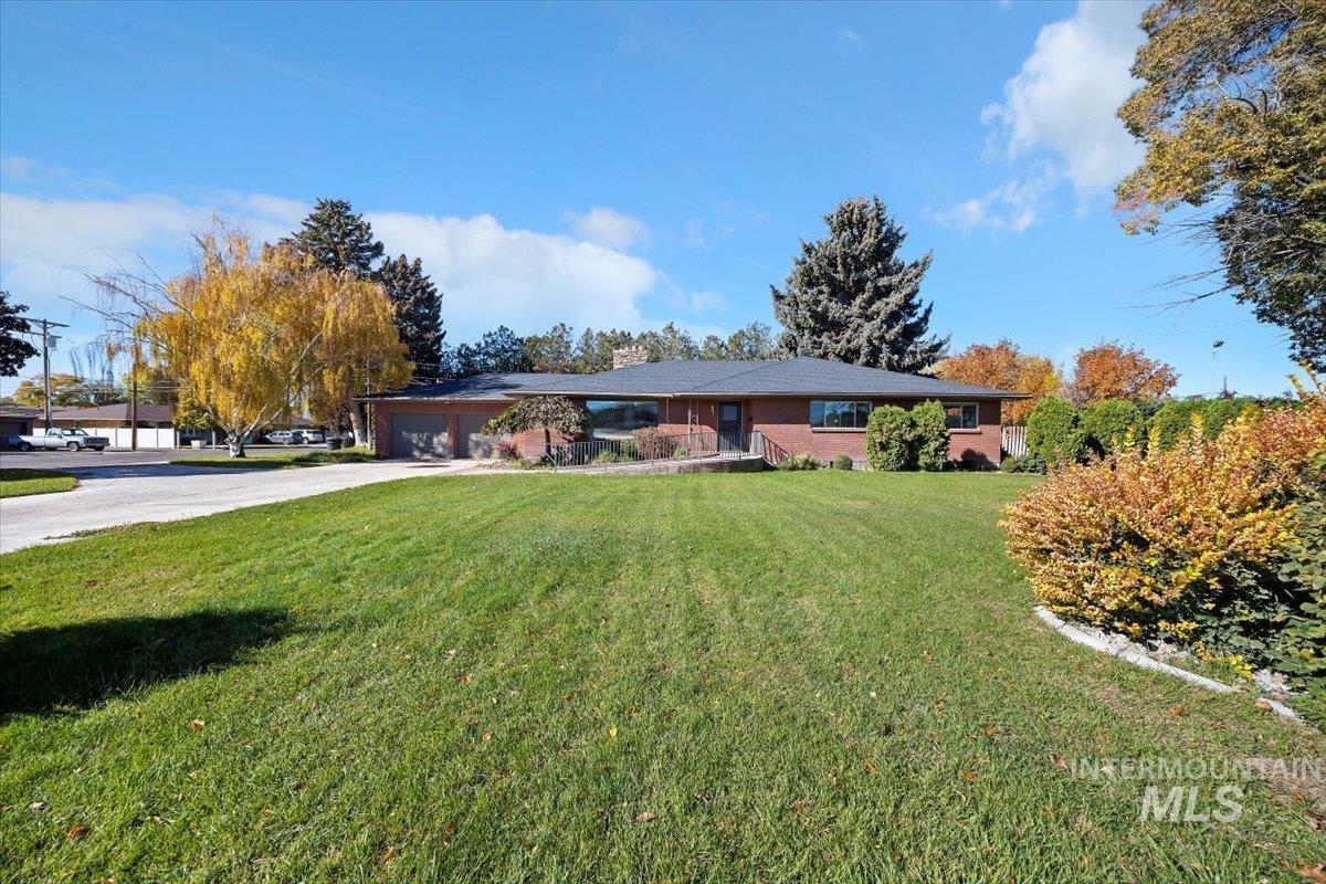 Ranch-style house featuring a front yard, driveway, and an attached garage