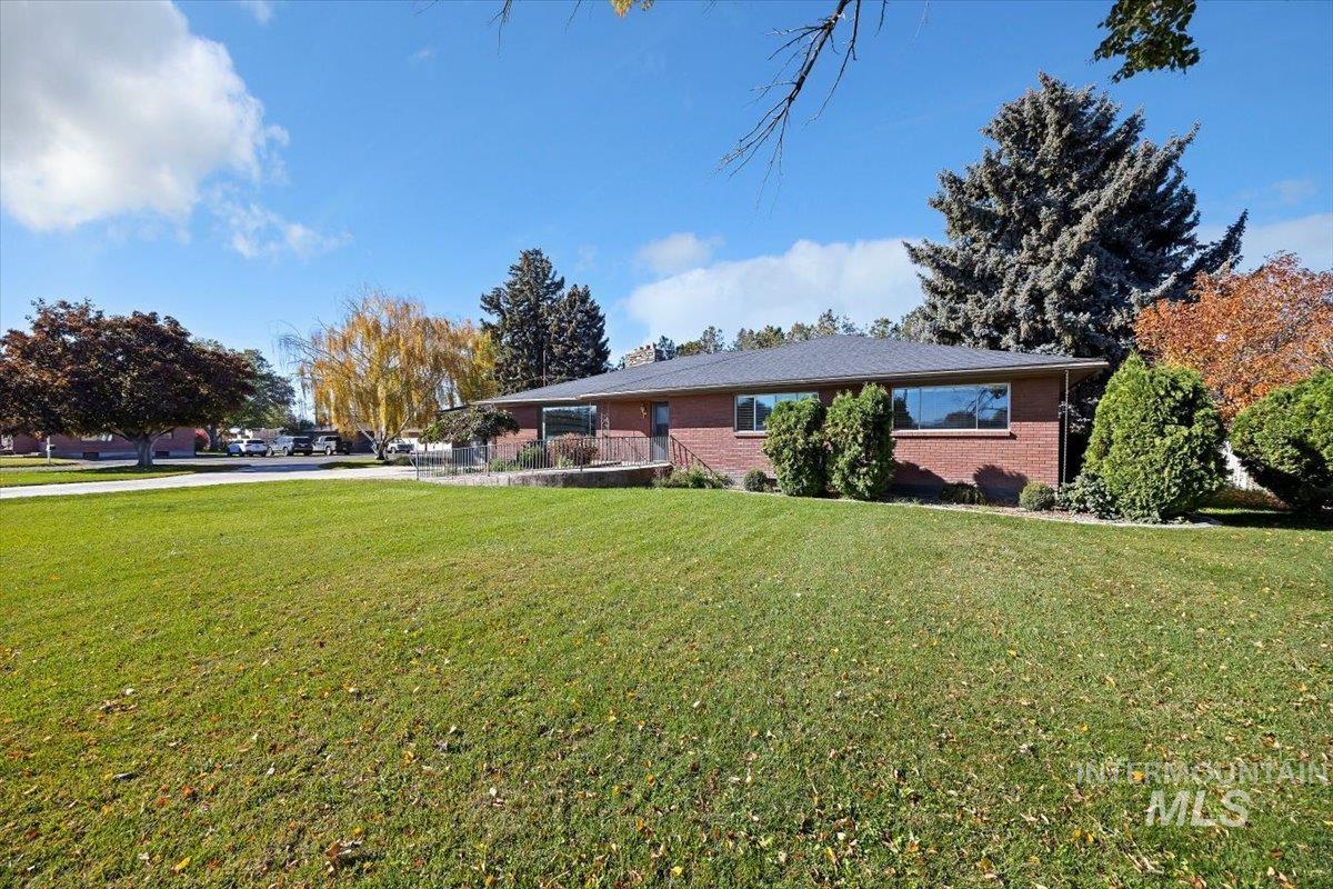 View of front of house featuring a front lawn and brick siding