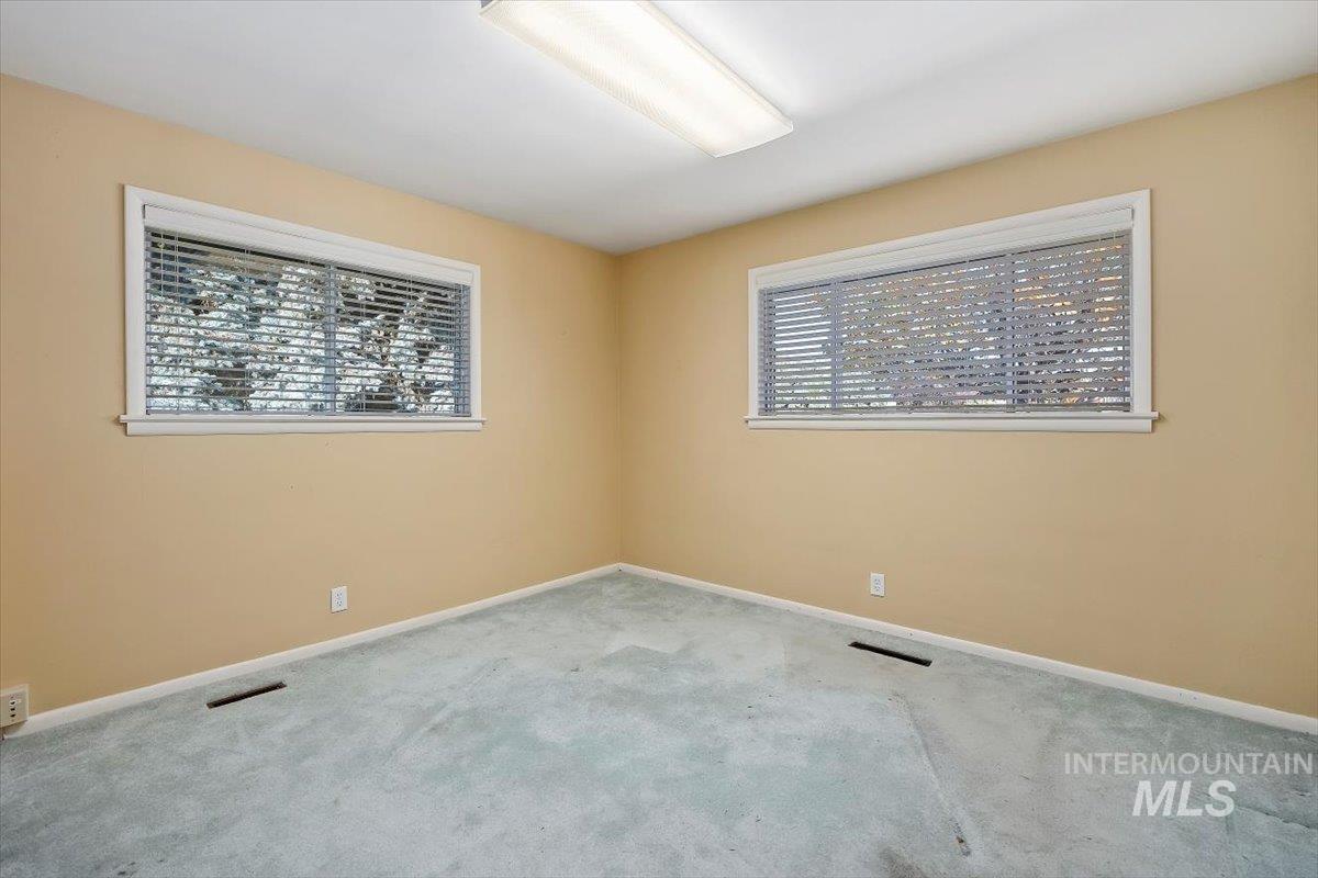Carpeted empty room featuring baseboards