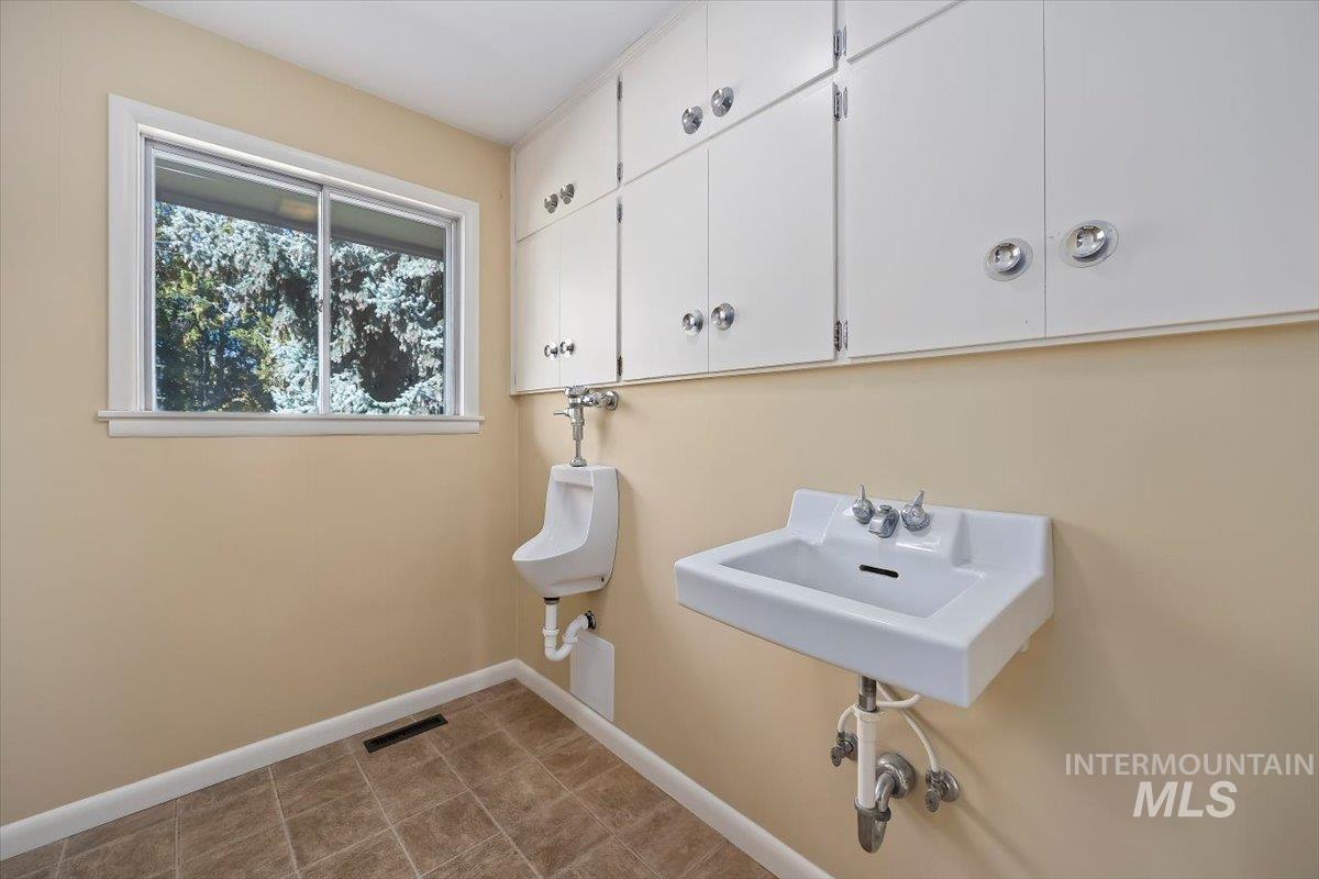 Laundry room with baseboards and a sink