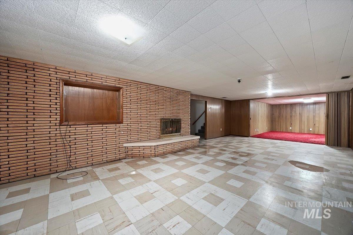 Finished below grade area with stairway, wooden walls, and light flooring