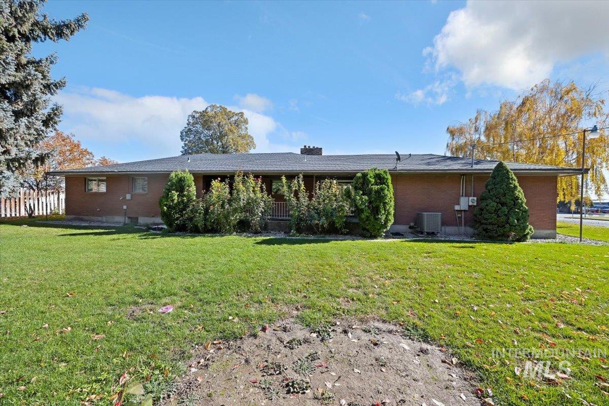 Back of house with brick siding and a chimney