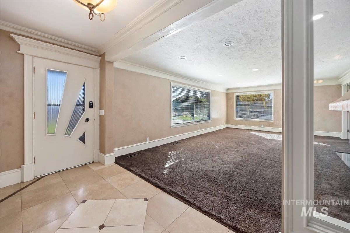 Entrance foyer featuring ornamental molding and light tile patterned flooring