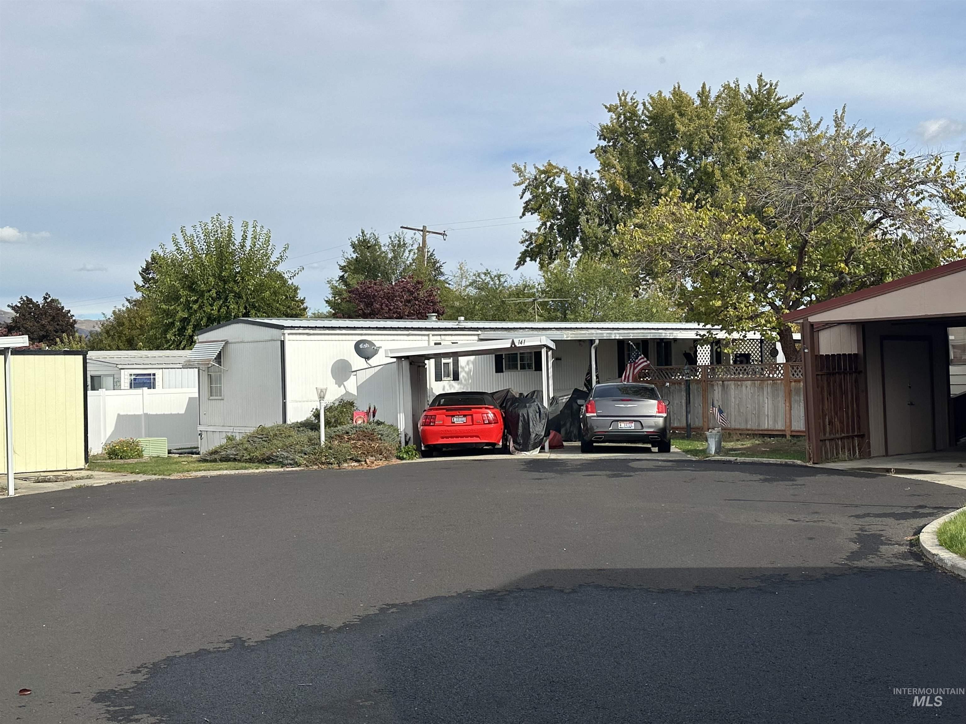 View of car parking with a carport and asphalt driveway