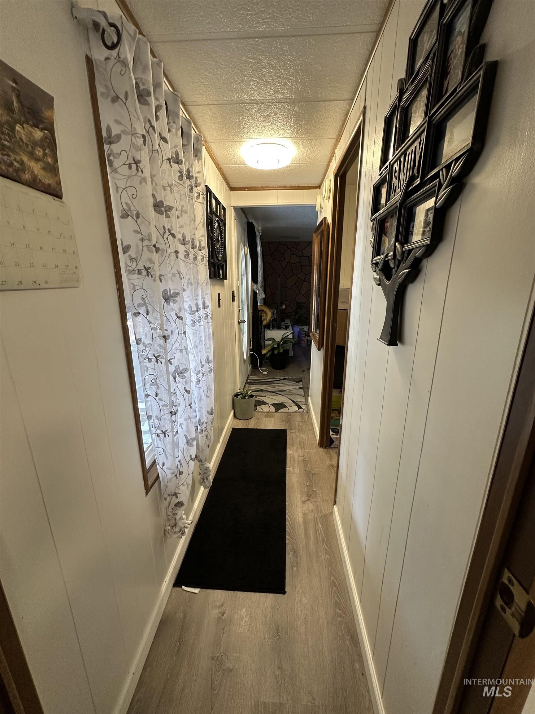 Hallway featuring wood finished floors and a textured ceiling