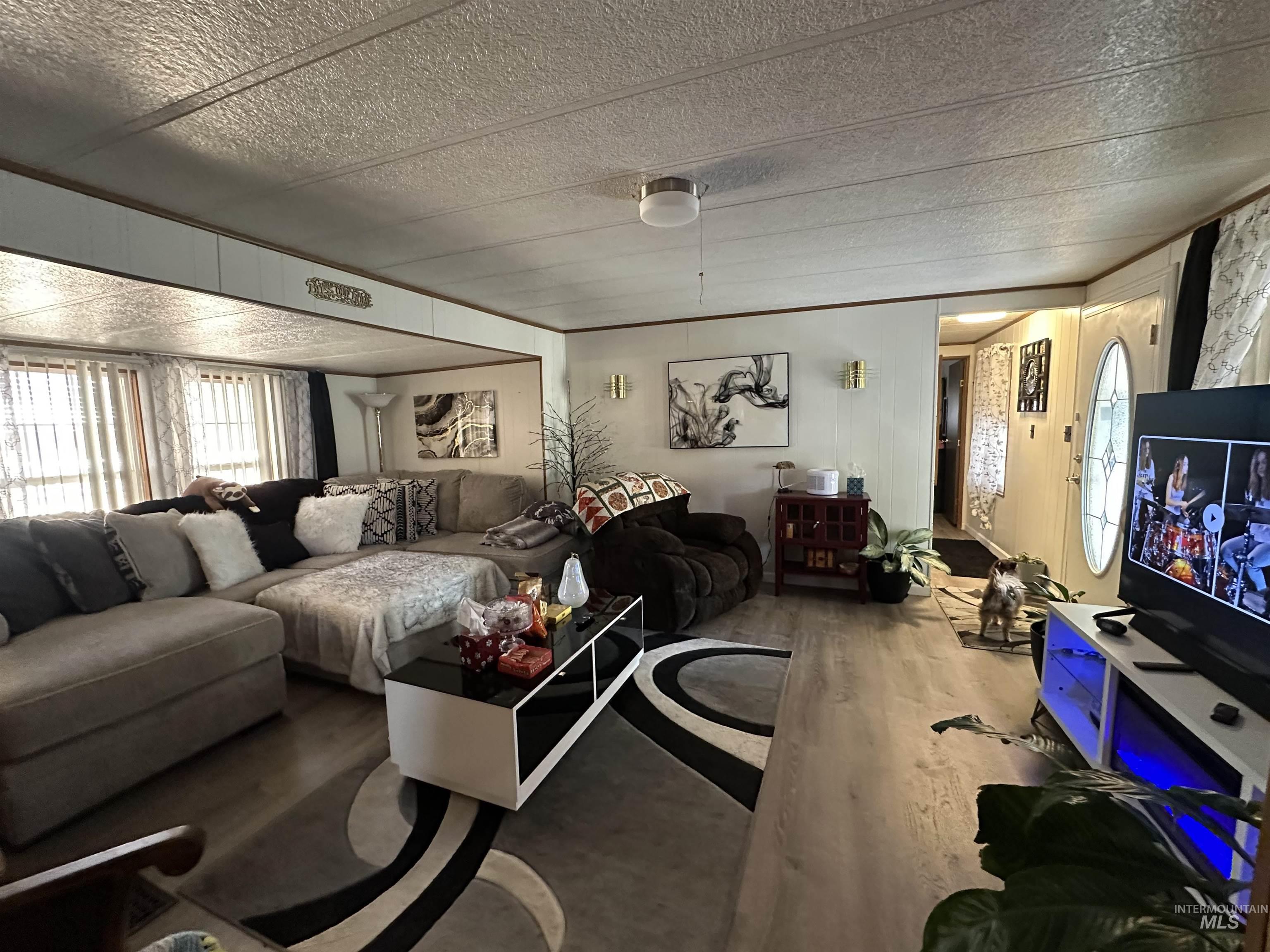 Living area featuring wood finished floors and a textured ceiling