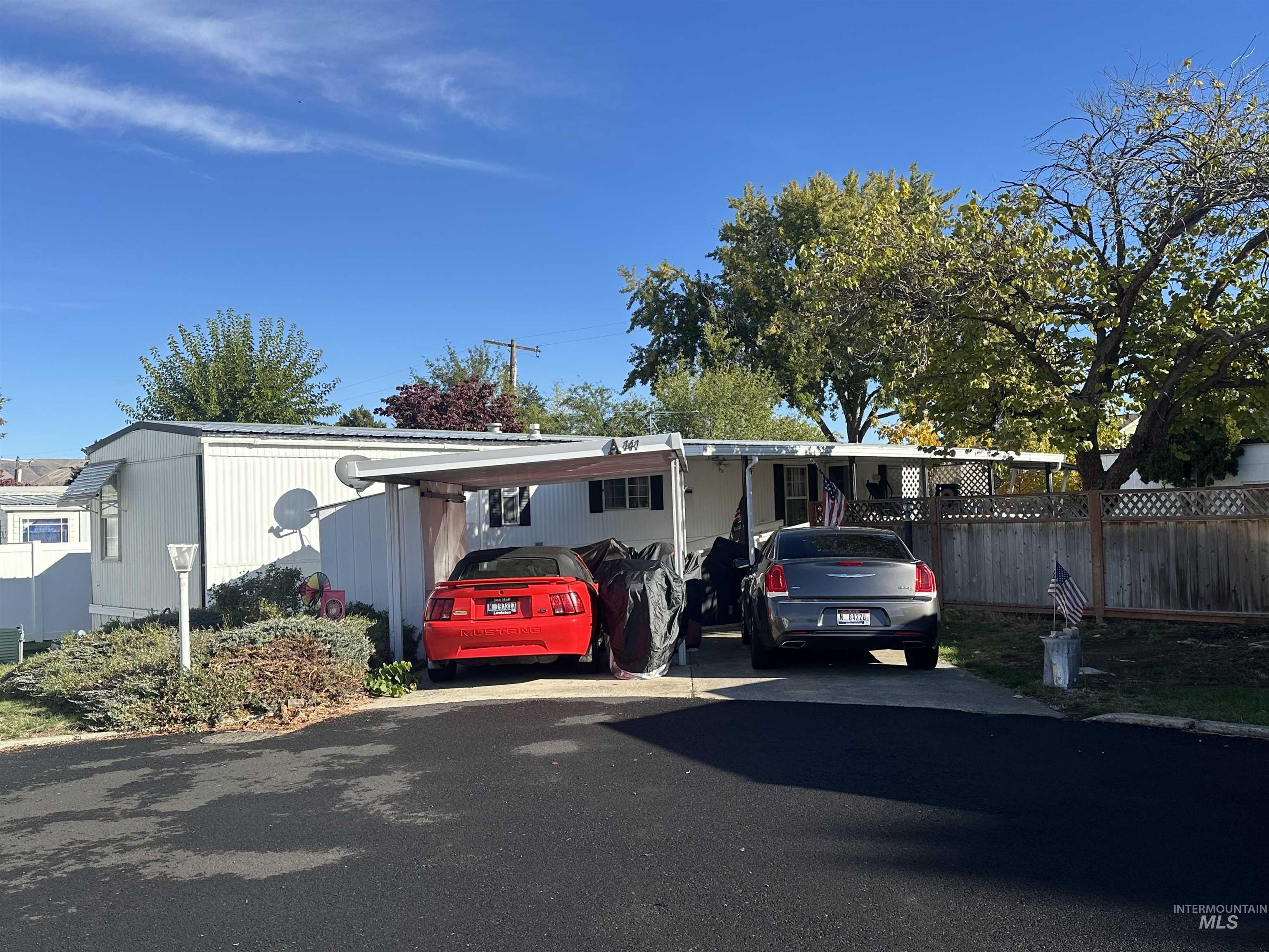 View of front facade with driveway and a carport