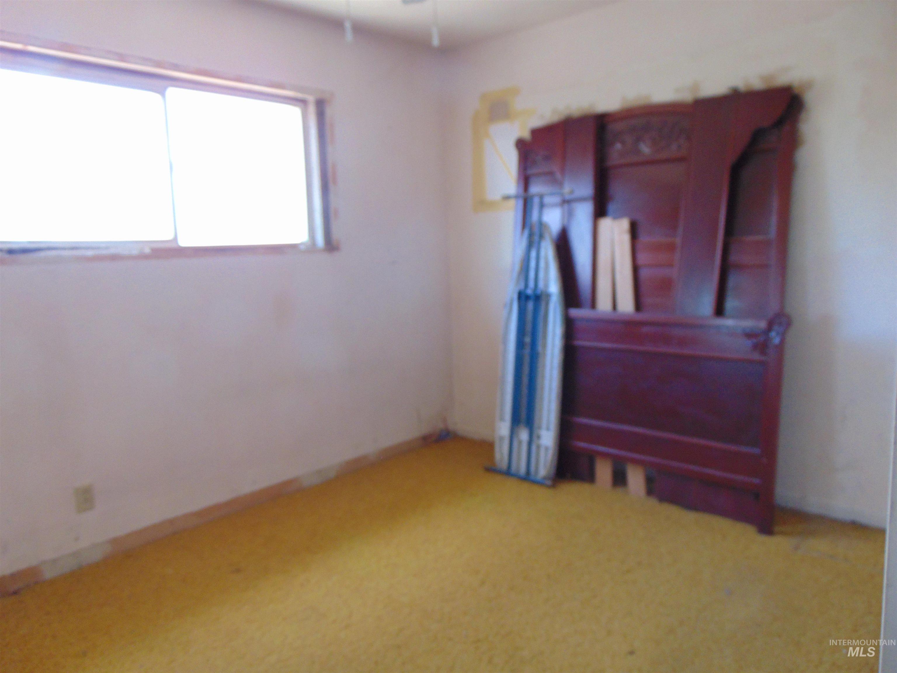 Unfurnished bedroom with light colored carpet and ceiling fan
