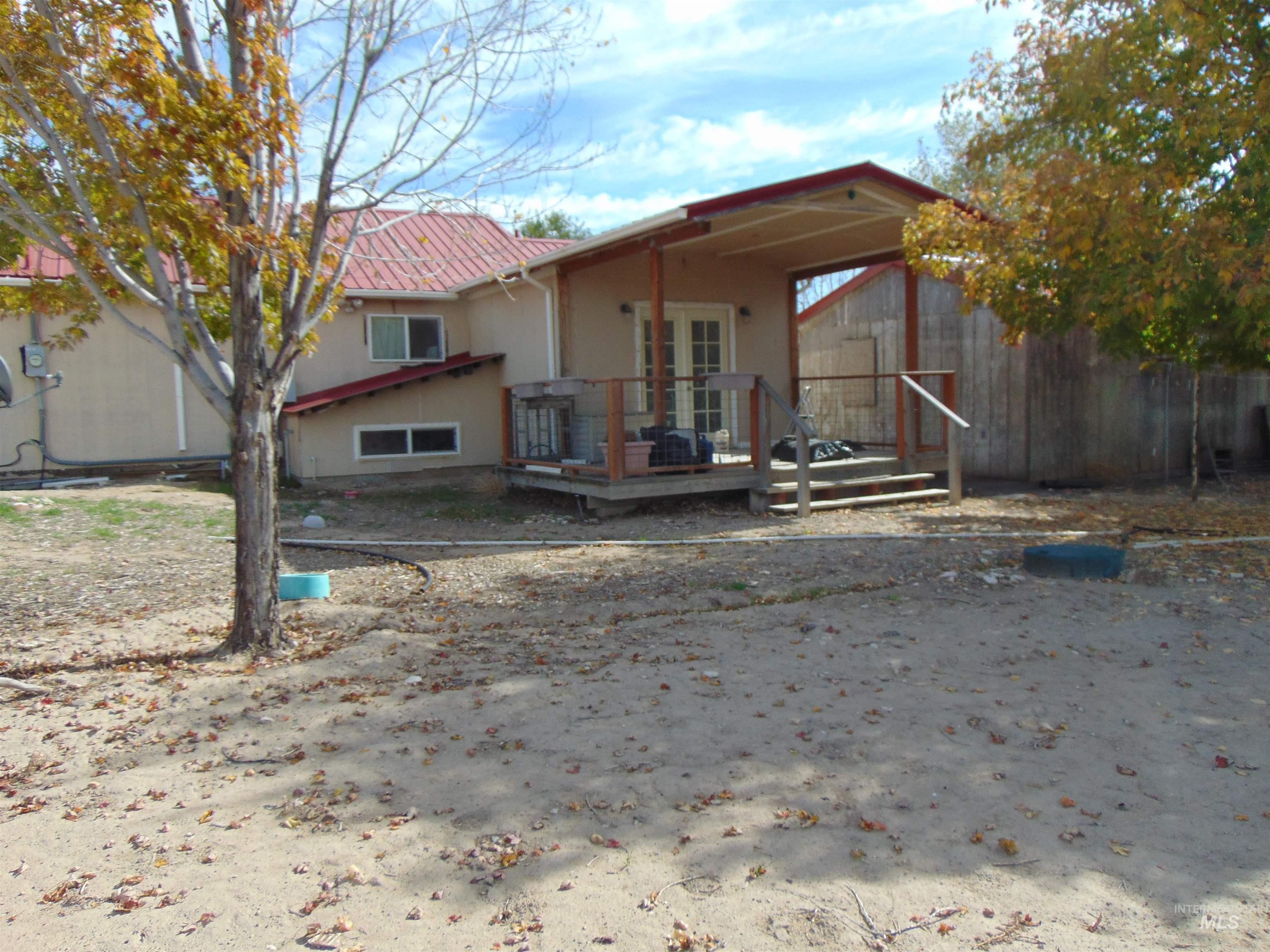 Rear view of house featuring a wooden deck, stucco siding, and french doors
