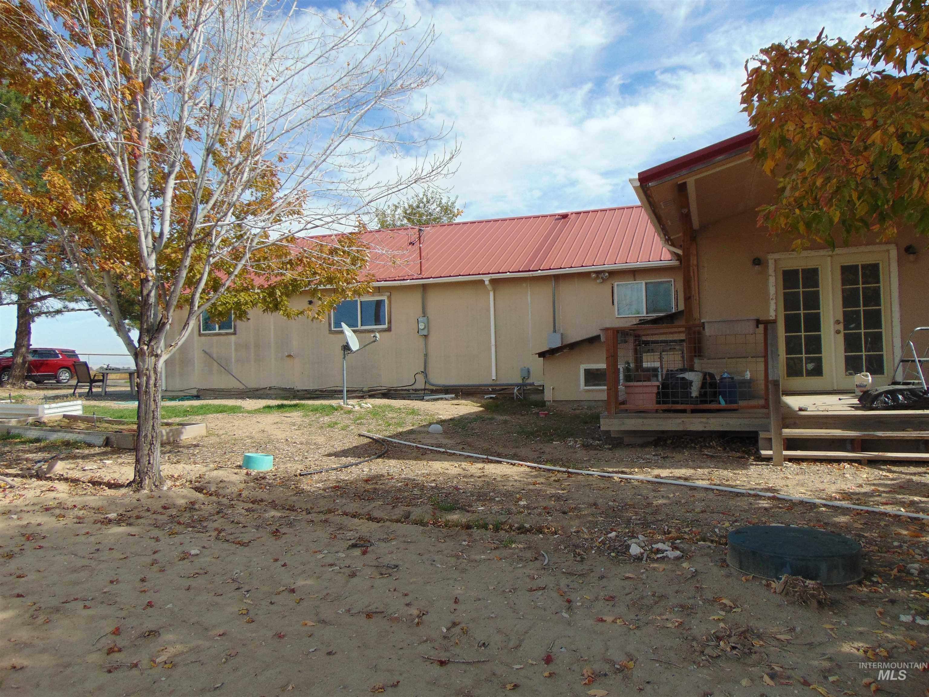 Back of property featuring a deck, french doors, and a metal roof