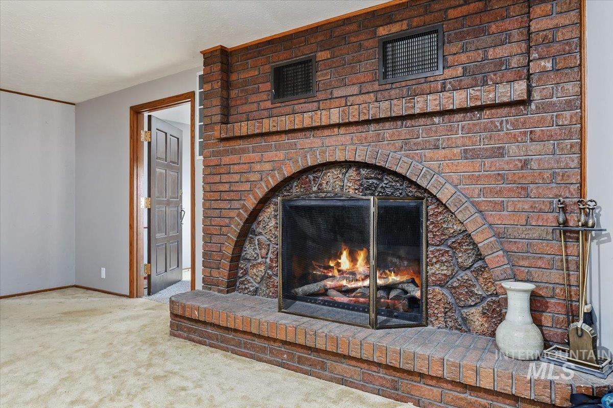 Detailed view of carpet and a brick fireplace
