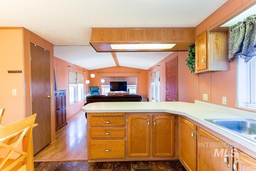 Kitchen with open floor plan, light countertops, a peninsula, and brown cabinets