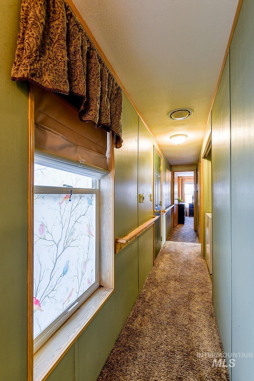 Corridor with carpet flooring and a decorative wall